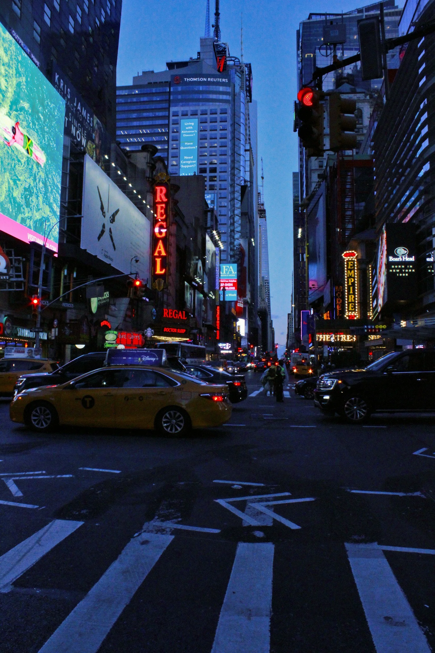 A modern house on a hill with mountains in the background and snow on the peaks.