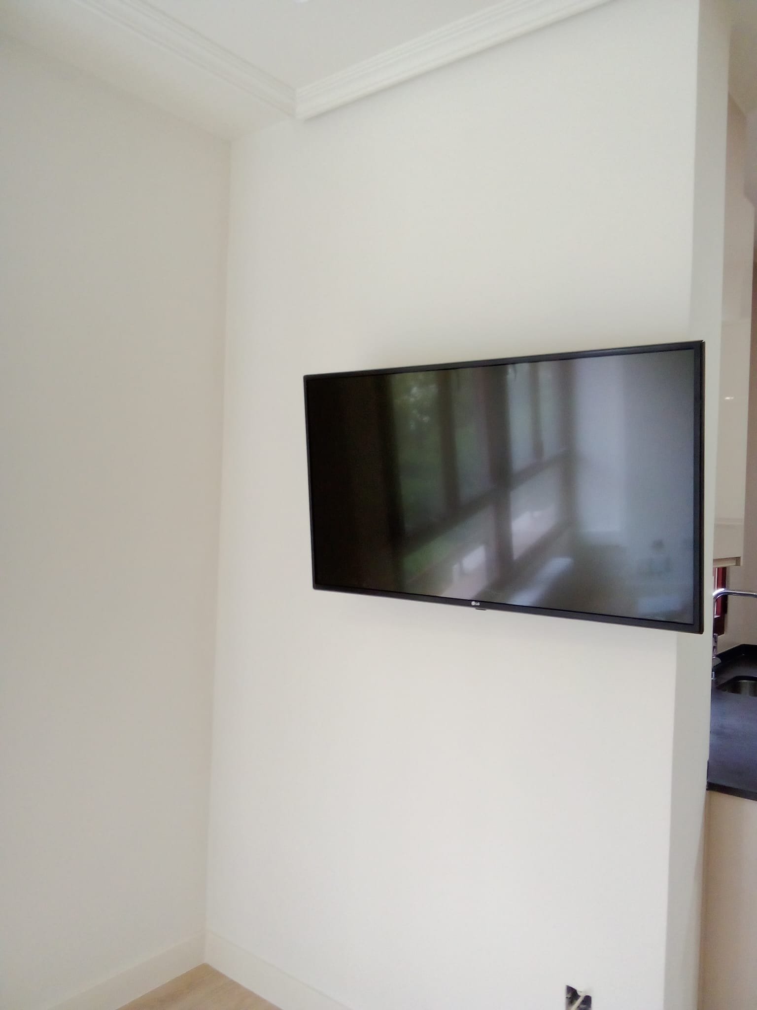 Pared blanca con televisor de pantalla plana montado