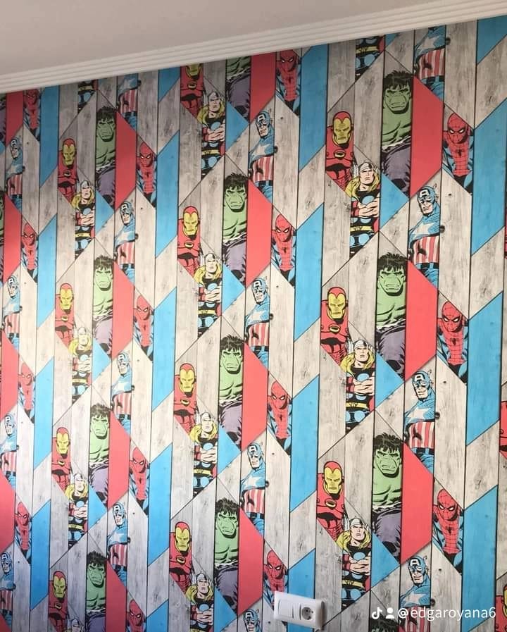 Revestimiento de pared decorativo con personajes de superhéroes como Iron Man, Hulk, Spider-Man y Capitán América en un patrón geométrico con colores rojo, azul, verde, blanco y gris.