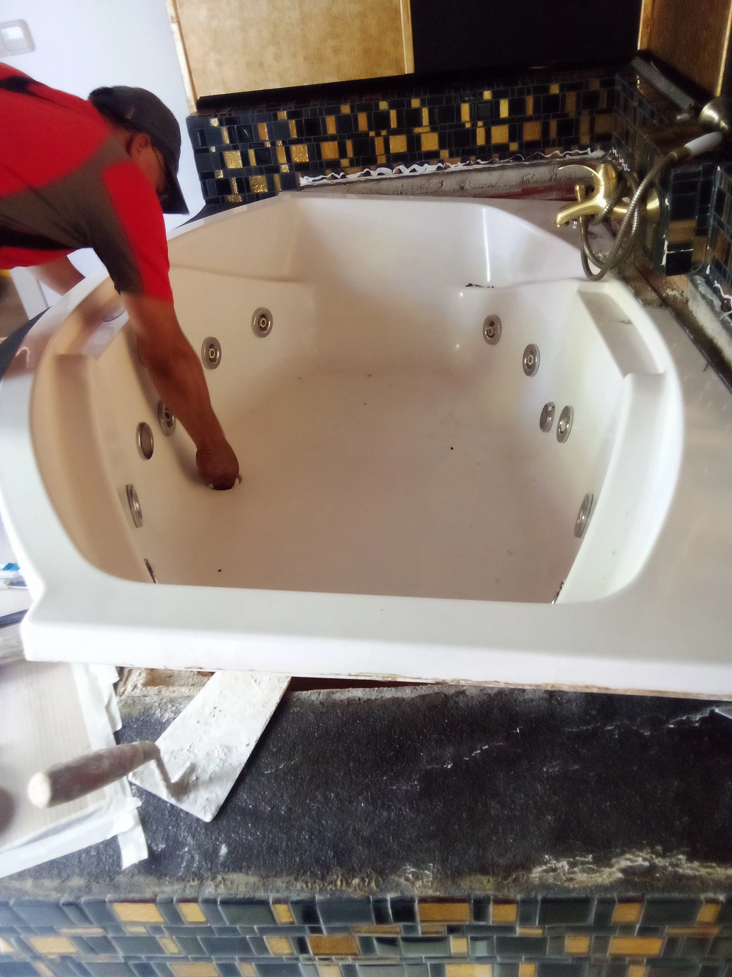 Persona instalando una bañera de hidromasaje en una encimera de granito.