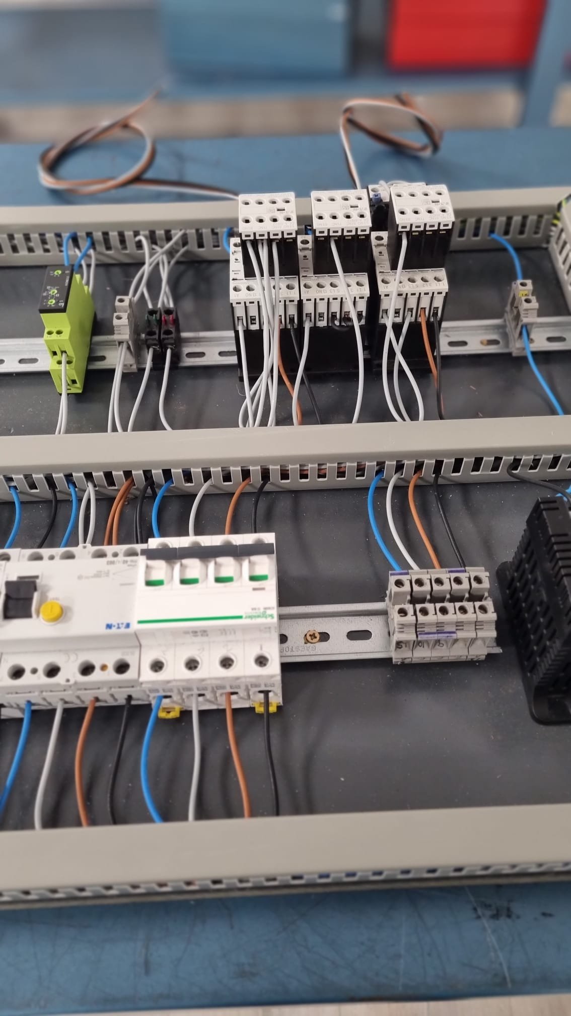 Panel de control eléctrico con cables conectados, incluyendo relés, interruptores y terminales, organizado en una caja de conexión para un sistema eléctrico.
