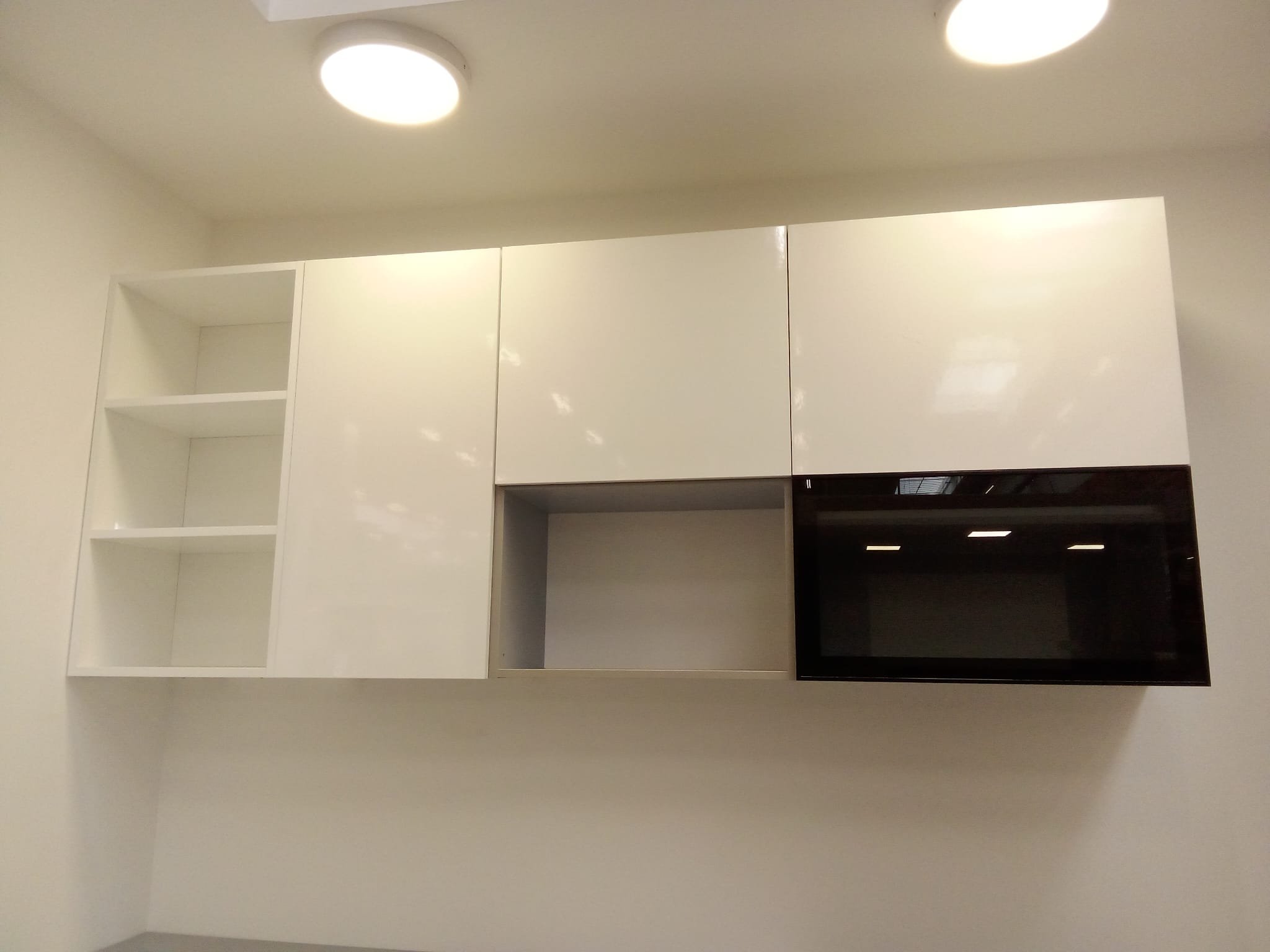 Gabinete blanco con estanterías abiertas y cerradas, y un espacio para una vitrocerámica.