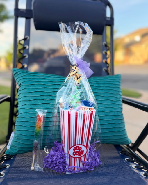 Three popcorn-themed gift bags with red, black, and white tissue paper inside, placed on a white surface.