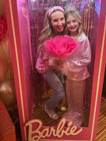 Pink Barbie-themed empty standing mirror frame with the Barbie logo at the bottom, placed against a green background.