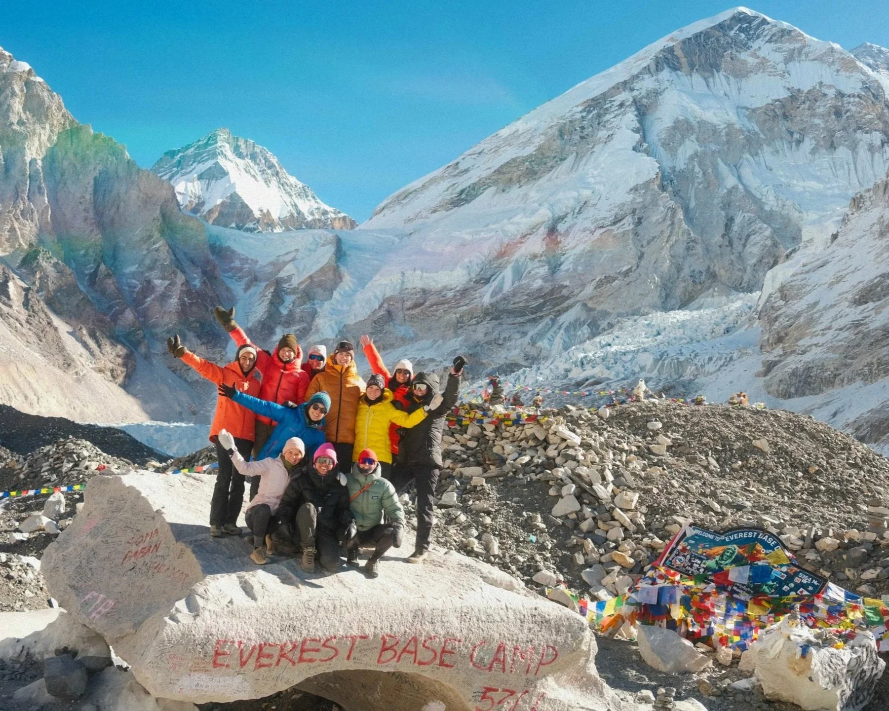 Gruppe von Wanderern am Mount Everest Base Camp mit hohen verschneiten Bergen im Hintergrund. Himalaya Erleben. Gruppenreise Nepal. Everest Basecamp. Trekking zum Everest Basecamp. Nepal erleben. Fotografie Reise Nepal. Trekking Nepal. Himalaya.