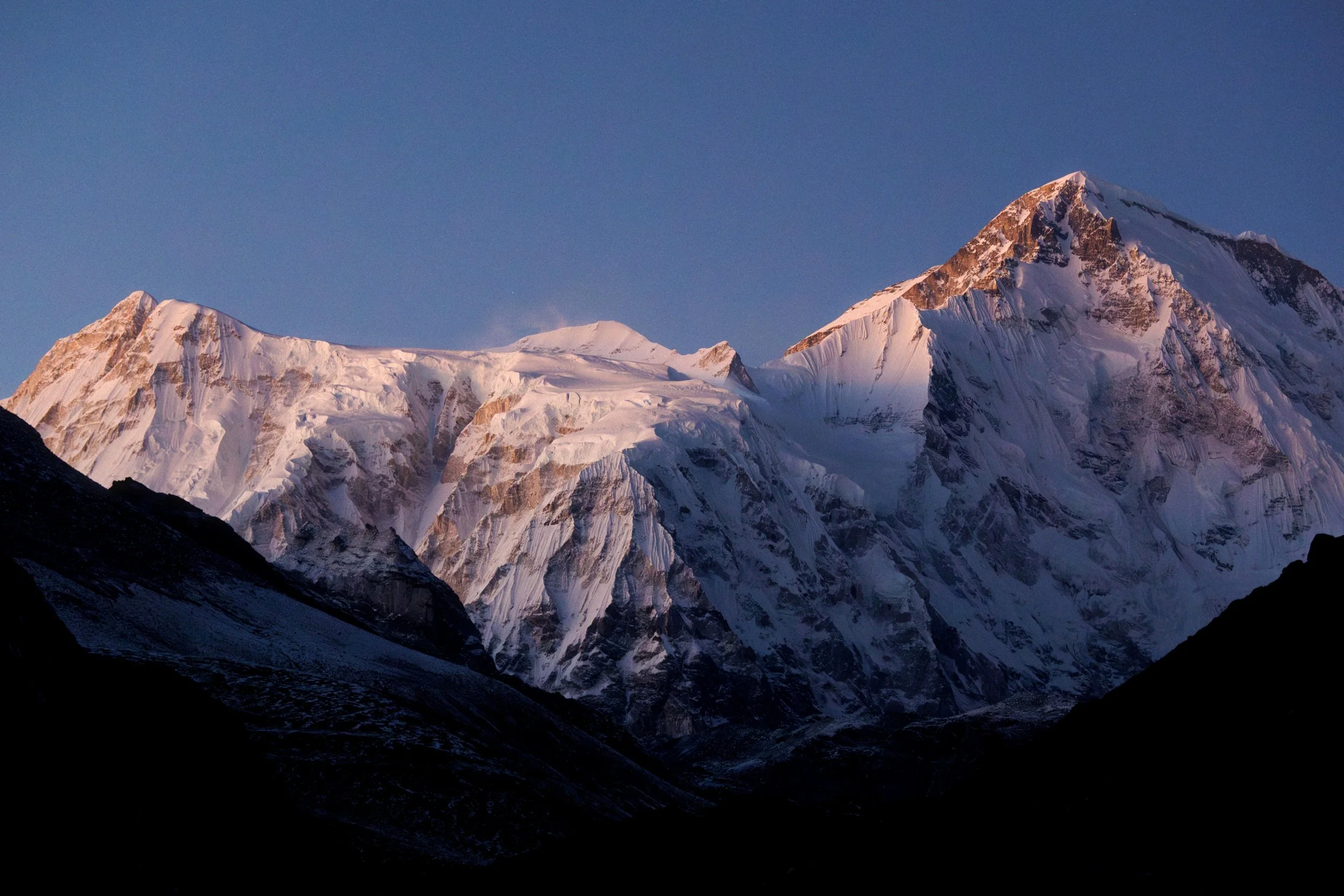 Berggipfel in Nepal mit schneebedeckten Gipfeln bei Sonnenaufgang oder -untergang, klare blauer Himmel. Fotografiereise Himalaya.