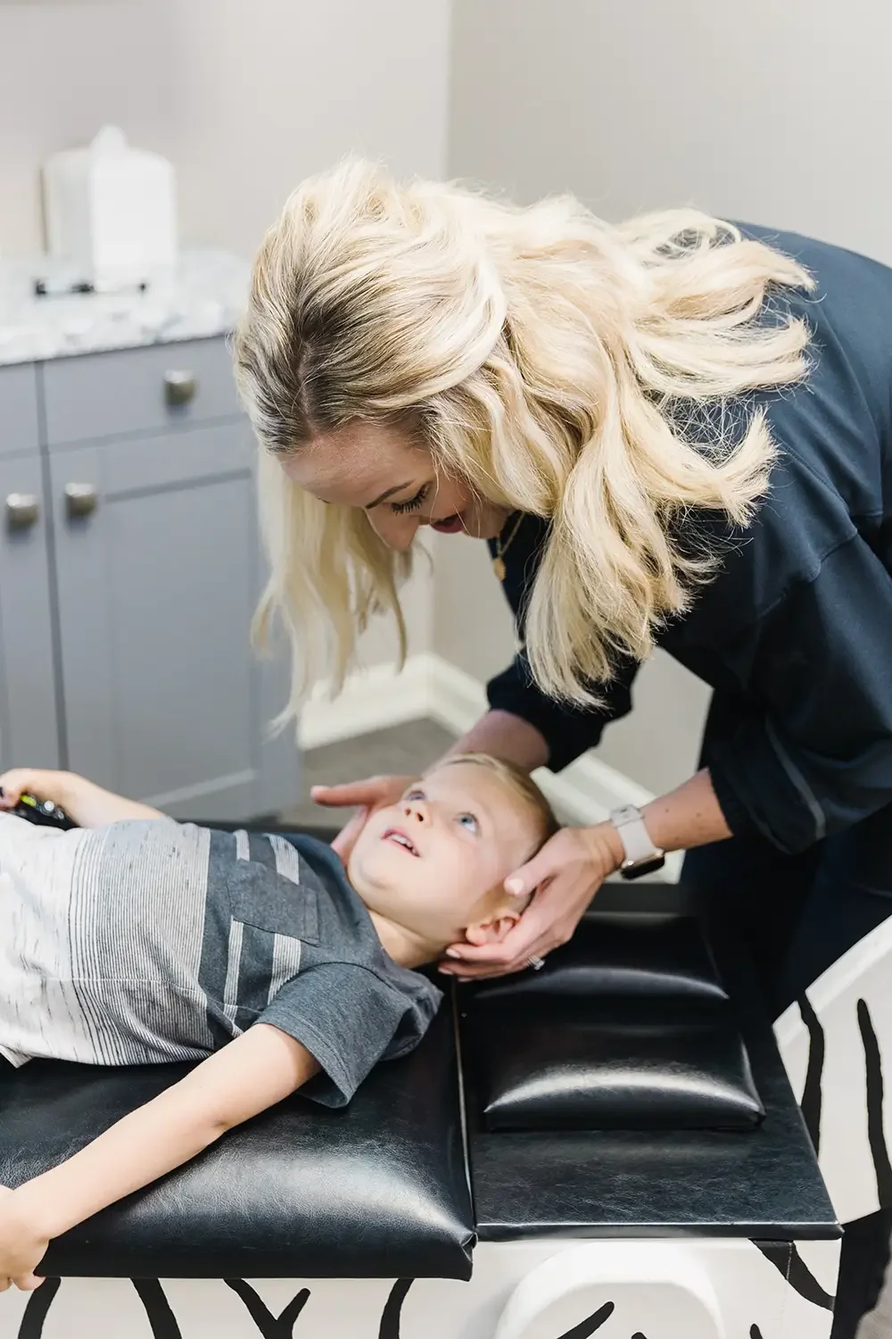 Dr. Ashley adjusting child during chiropractic visit in Sioux Falls