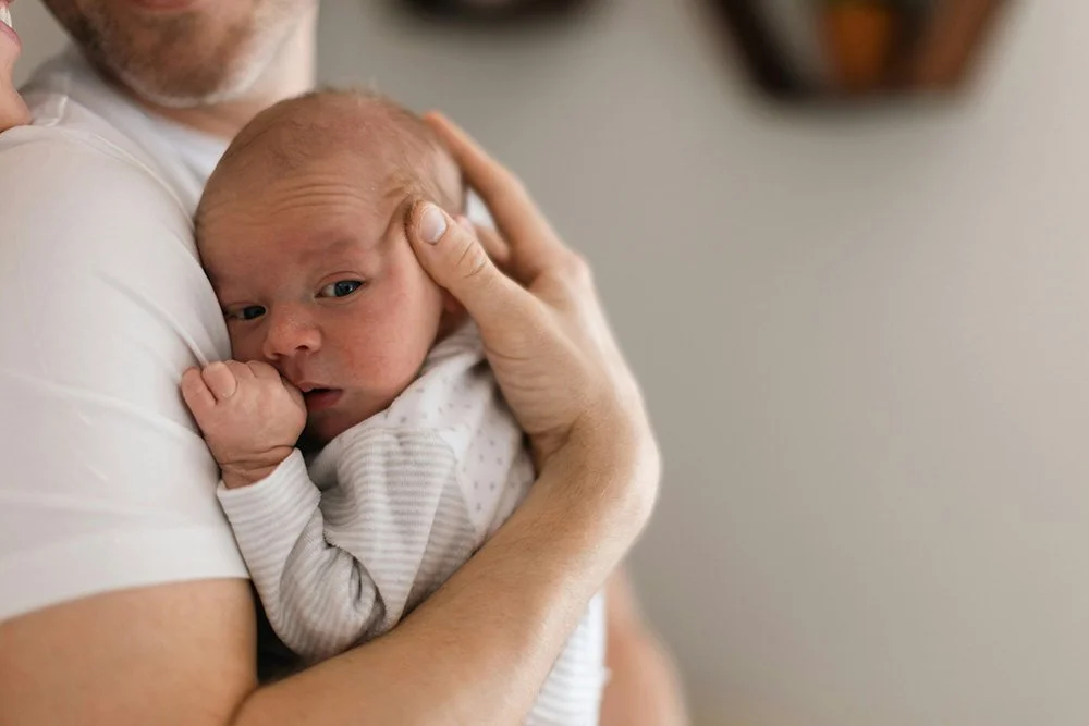 Dad holding newborn baby at chiropractic visit in Sioux Falls.