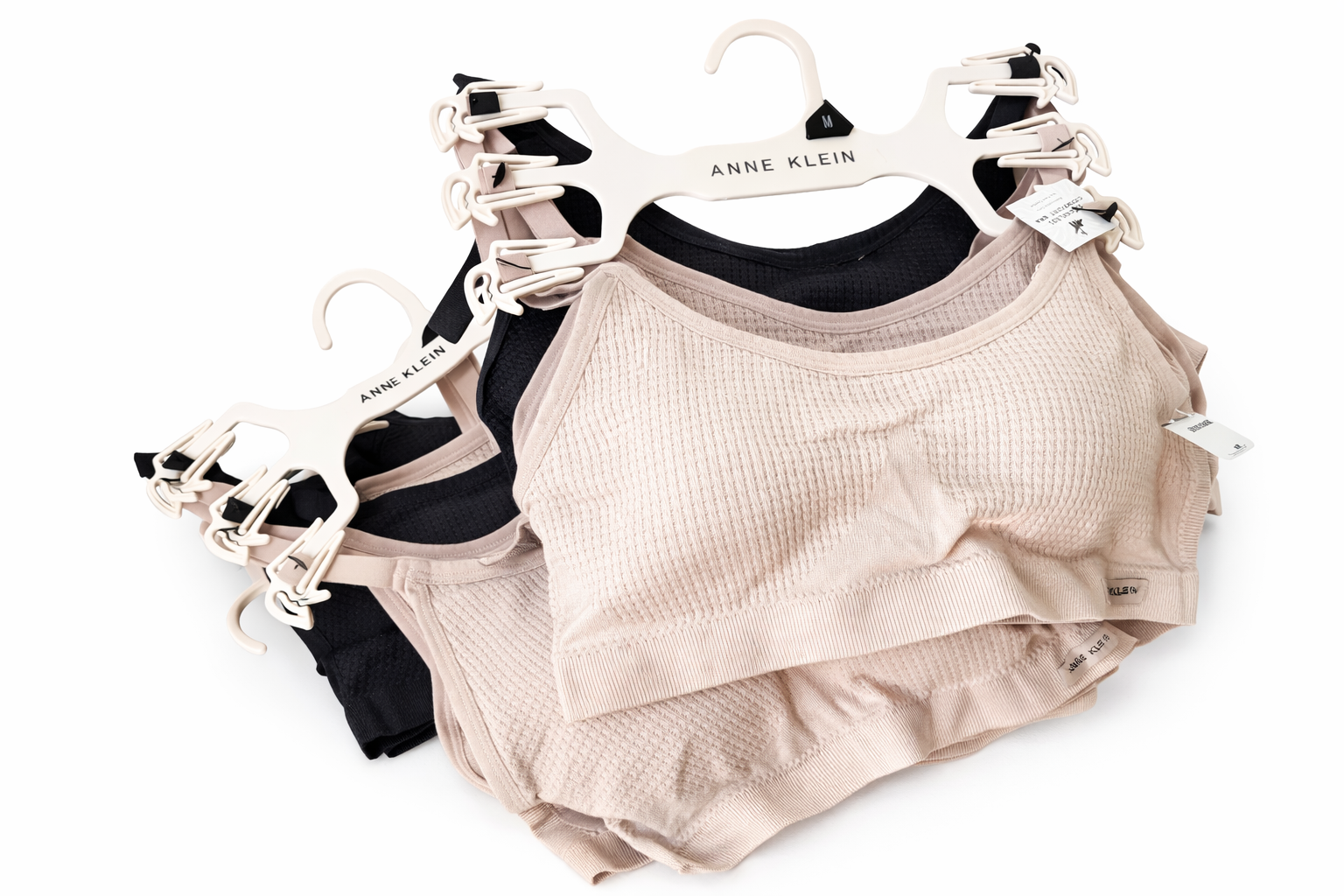 Stacked Anne Klein bras on hangers.png
