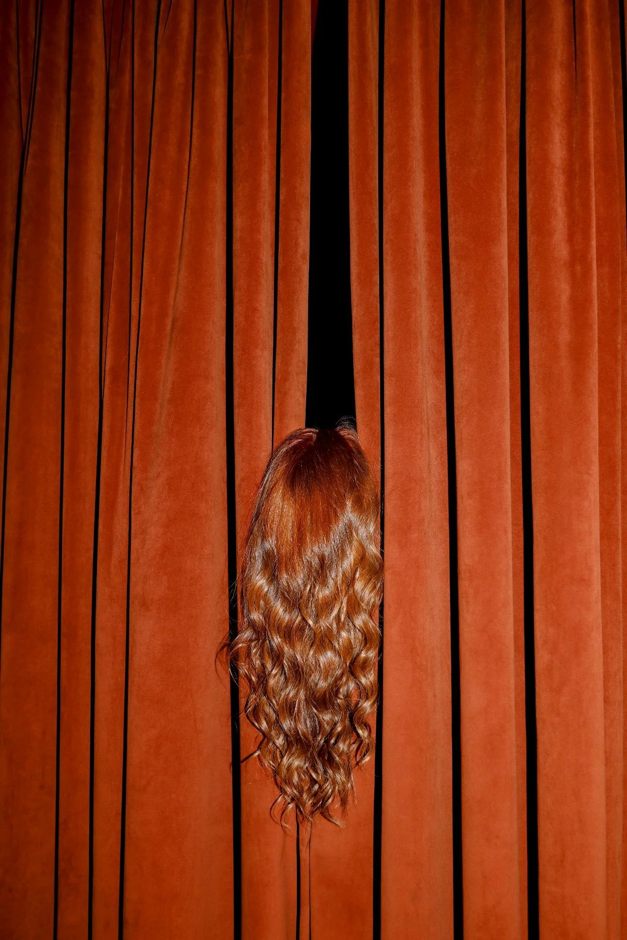 Person holding a clear glass sphere with a brown wooden background