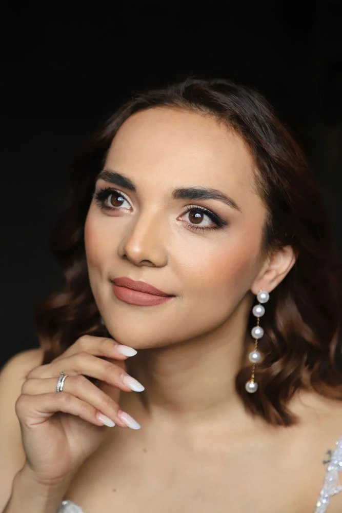 Die Braut in einem Hochzeitskleid posiert lächelnd für ein Foto.