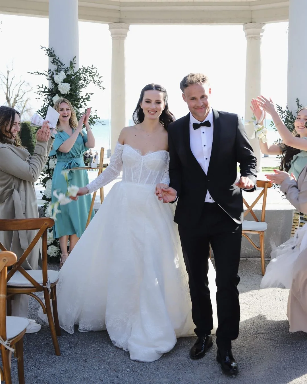 Bride runs after the outdoor wedding ceremony with guests in the background