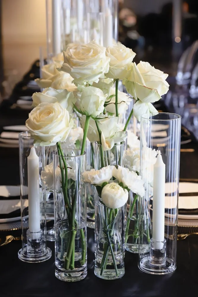 Ein Tisch, dekoriert mit weißen Rosen und Kerzen, ideal für eine festliche Stimmung.