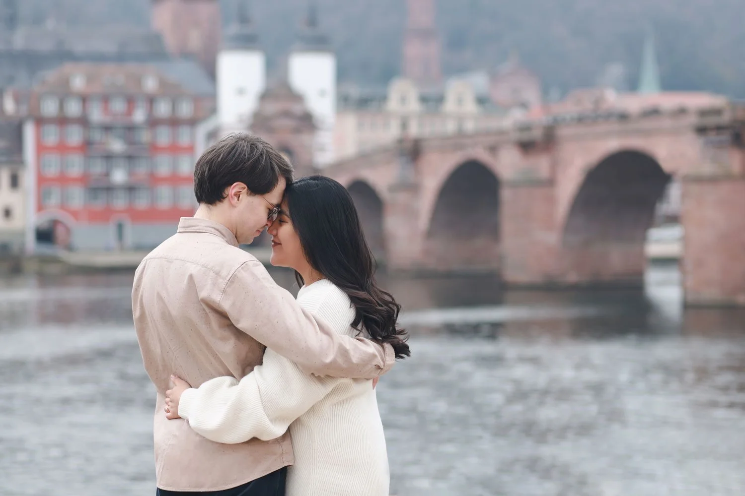 A happy couple in Heidelberg enjoys a loving moment in the historic city.