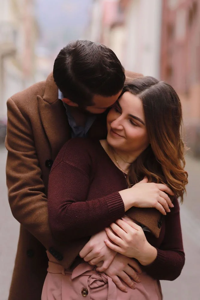 A couple embraces warmly on a city street in Heidelberg.