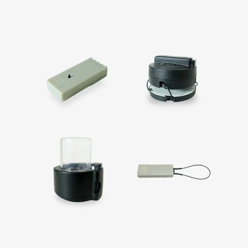 Collection of electronic devices and accessories including a remote control, a black circular device, a small black appliance with a clear lid, and a rectangular white device with a strap
