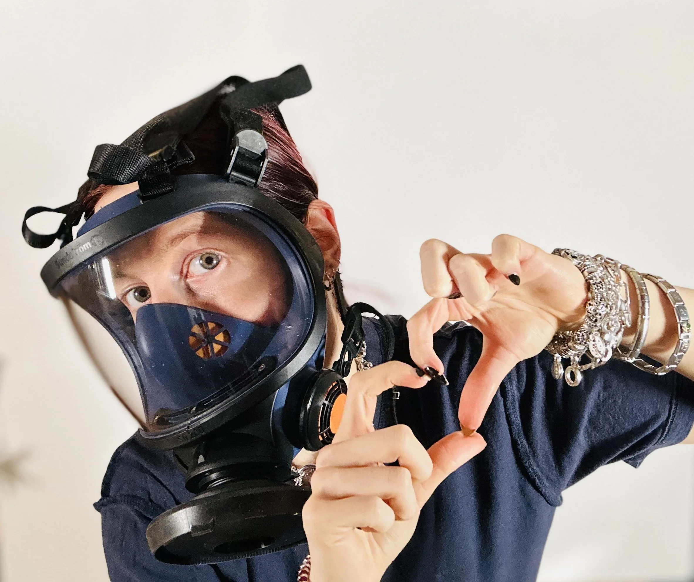 Person trägt einen Tauchhelm und zeigt mit den Händen einen herzförmigen Blick.