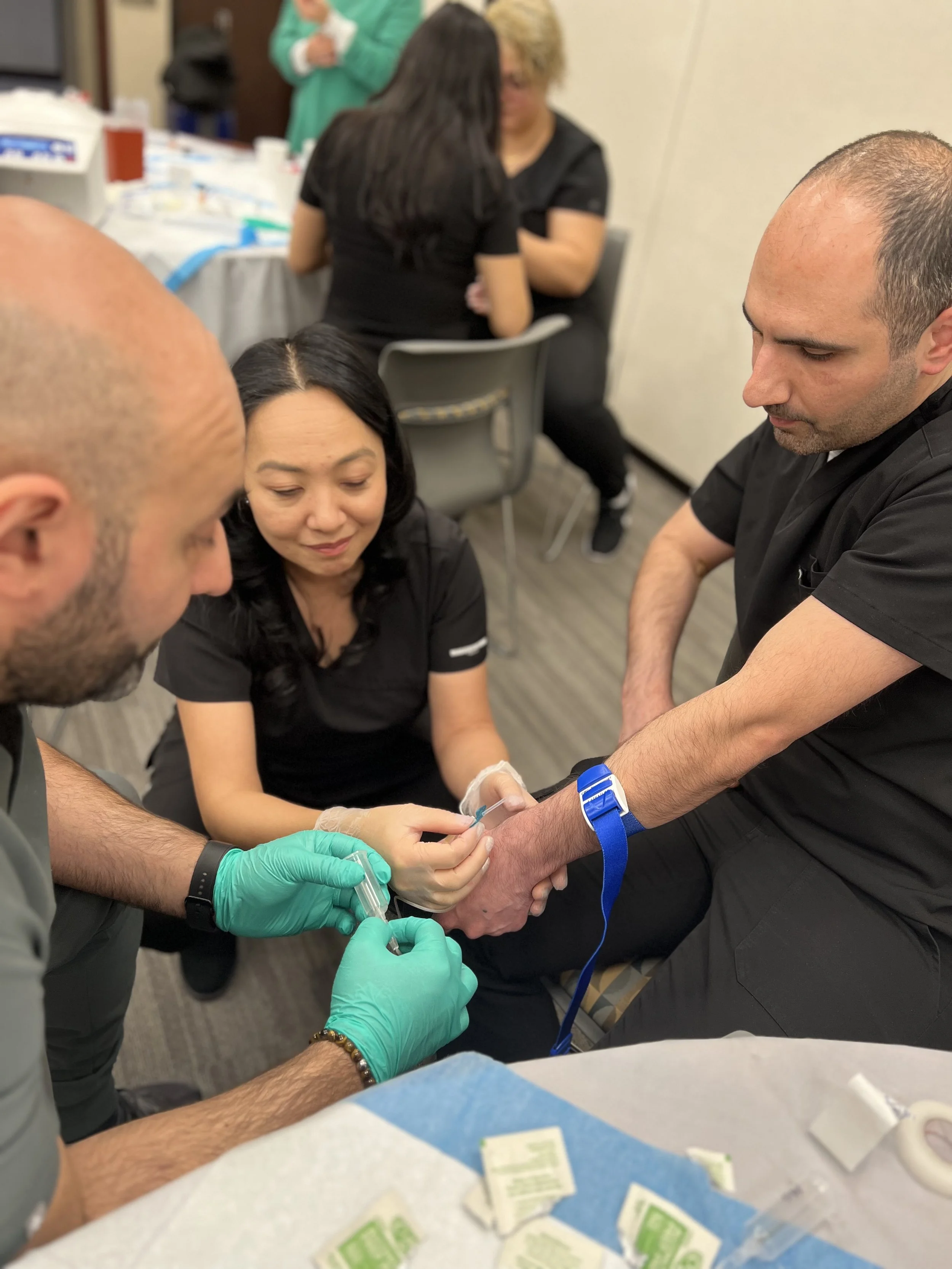 Dental implant professionals administering a shot to a man in a clinical training setting.