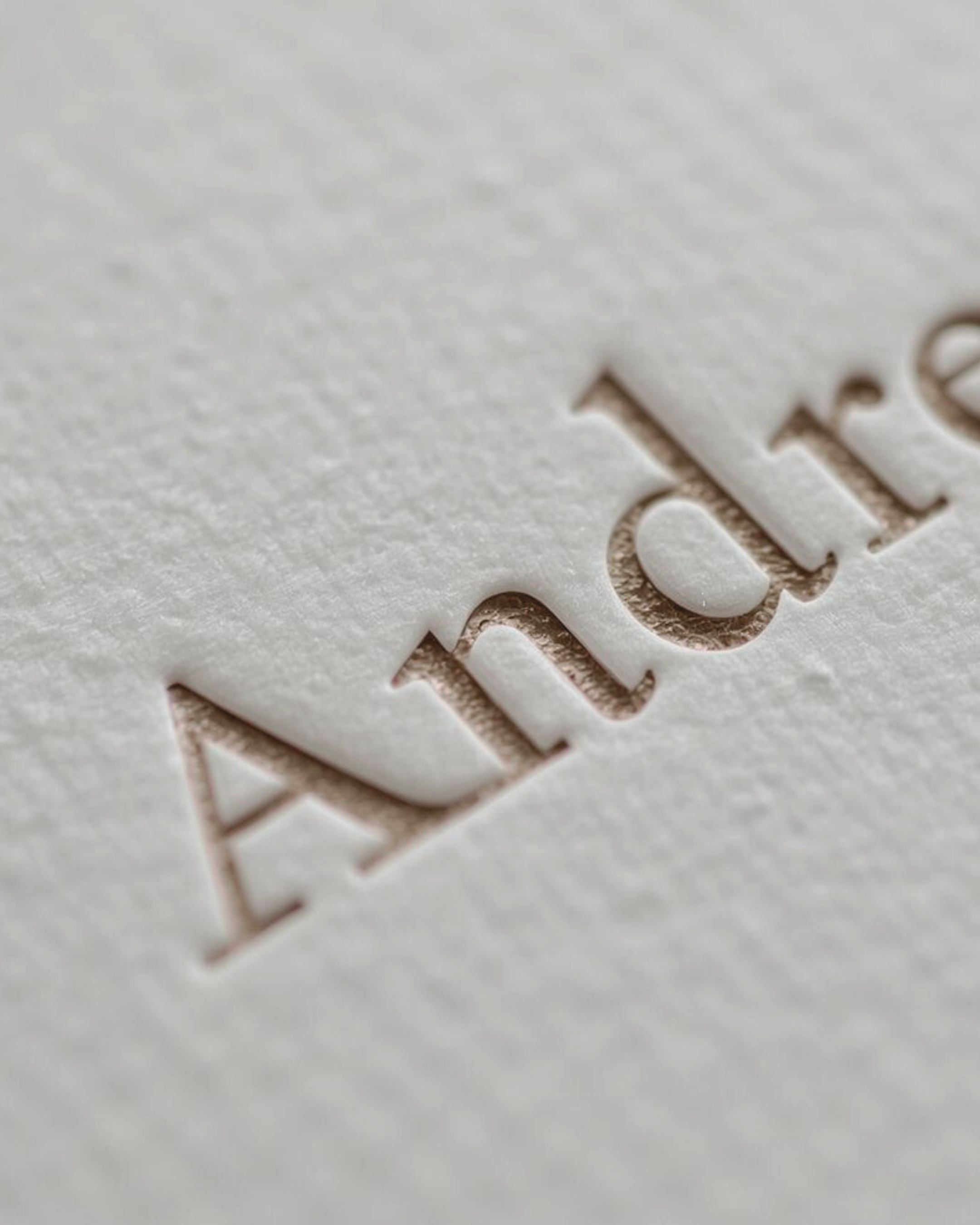 Close-up of the textured surface of an envelope or card with the word 'ARRIVAL' embossed or cut out.