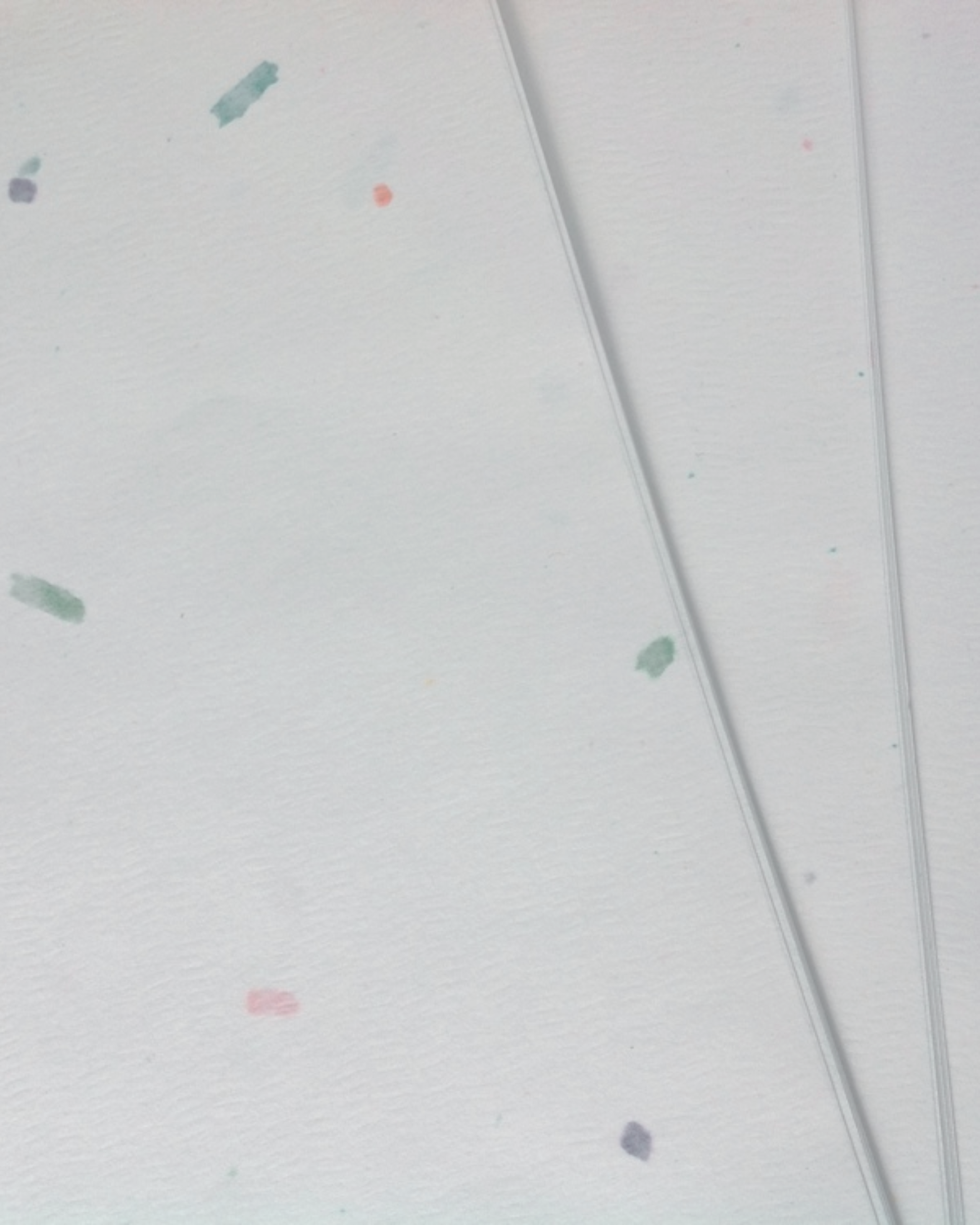 Close-up image of a light-colored wall with small, scattered paint splatters and two thin, parallel lines.