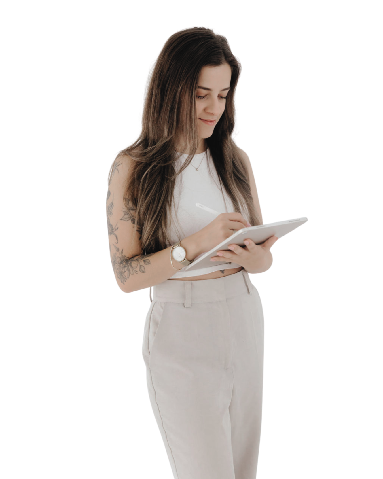 A woman with long brown hair and tattoos on her left arm, wearing a white sleeveless top, white pants, a watch, and a necklace, writing on a notepad with a pen.