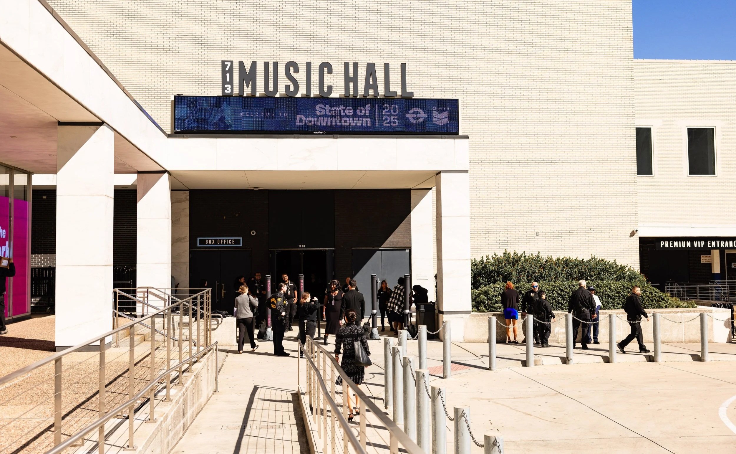 People waiting in line outside the Chicago Symphony Center, also known as the Symphony Center, with signs indicating the venue is for a music event downtown Chicago.