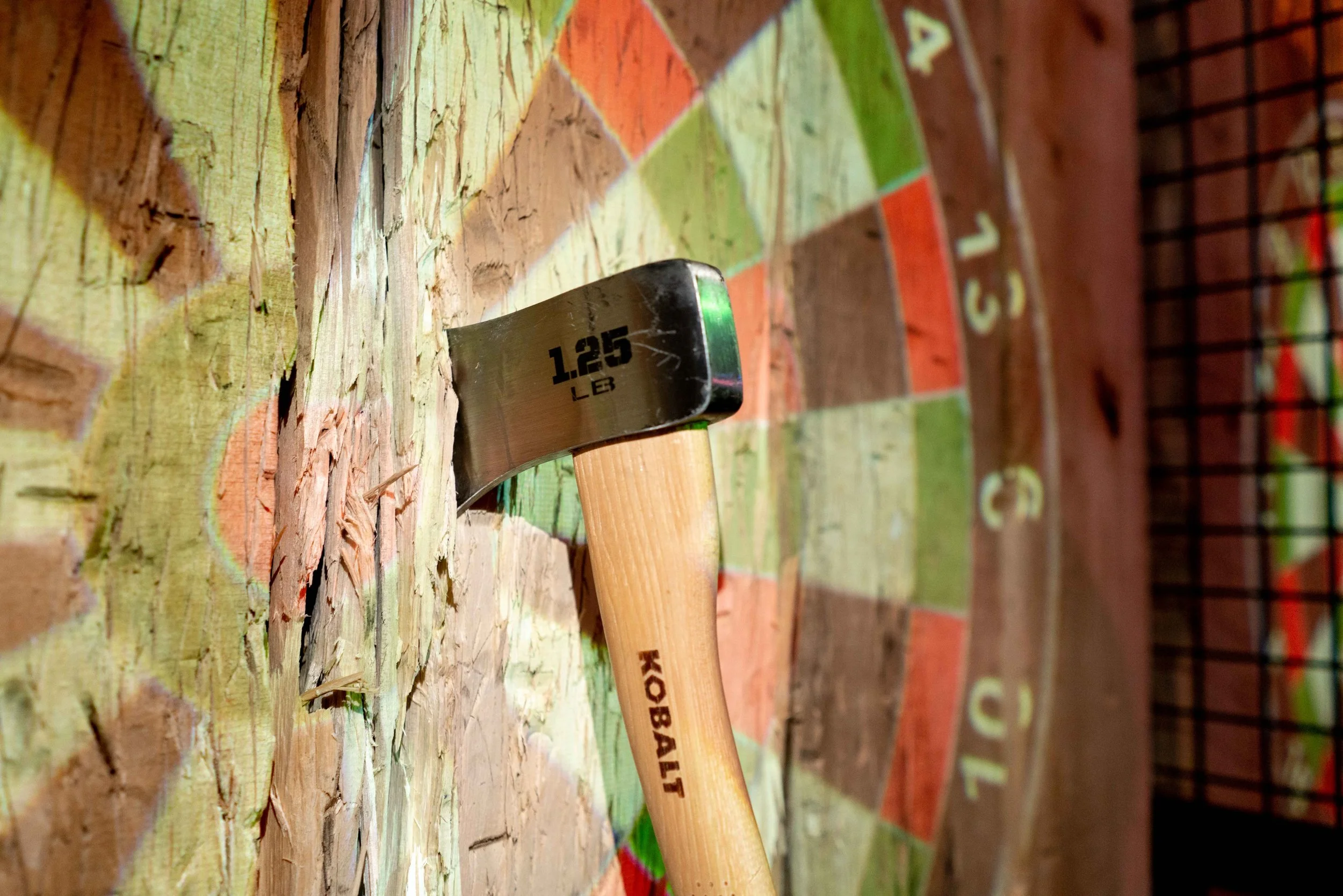 Axe stuck in wood with a dart board projection