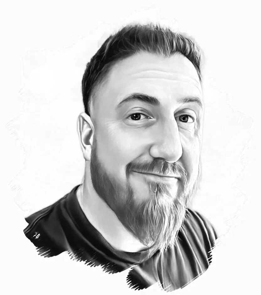 Black and white portrait of a man with a beard and mustache, smiling slightly, looking at the camera, wearing a dark shirt.