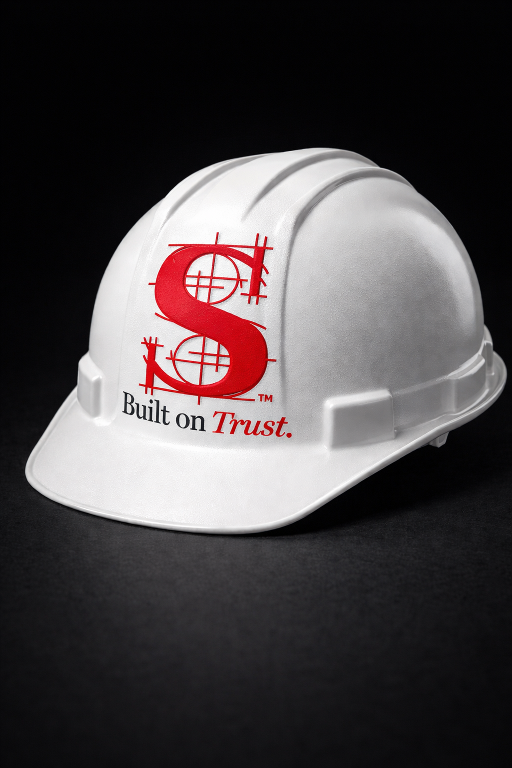 White construction helmet with a red logo and the words "Built on Trust." on a black background.
