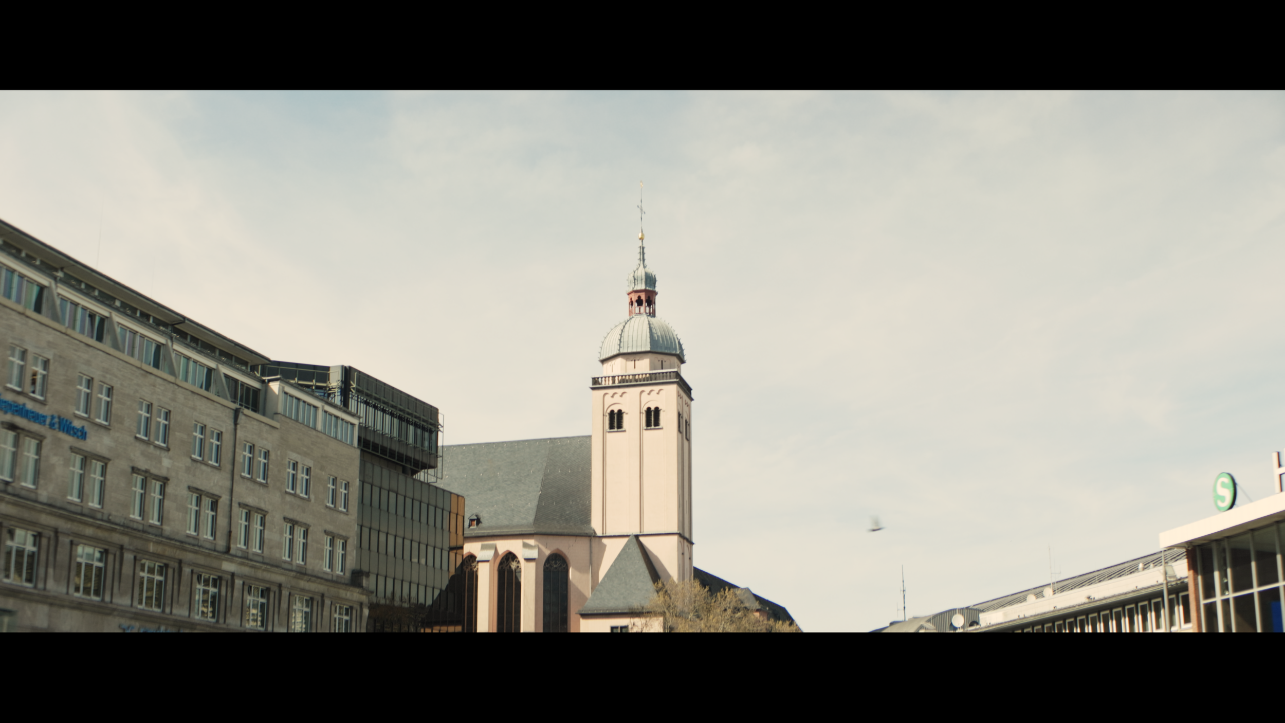 Kirchturm in Köln zwischen moderner Architektur im weichen Cinematic Look – aufgenommen mit Blazar Mantis 50mm