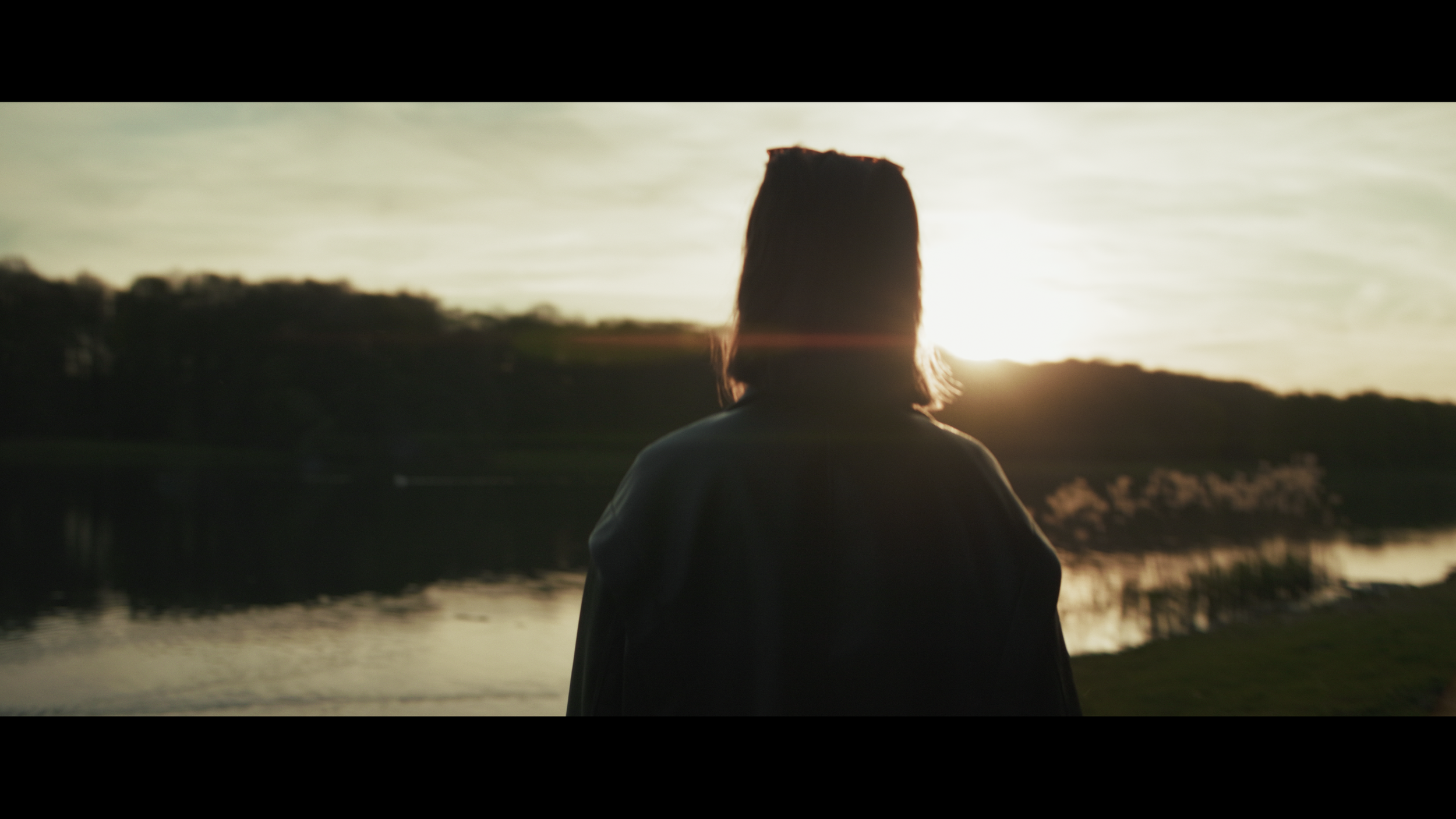 Silhouette einer Person im Sonnenuntergang mit anamorphic Lens Flare in Köln