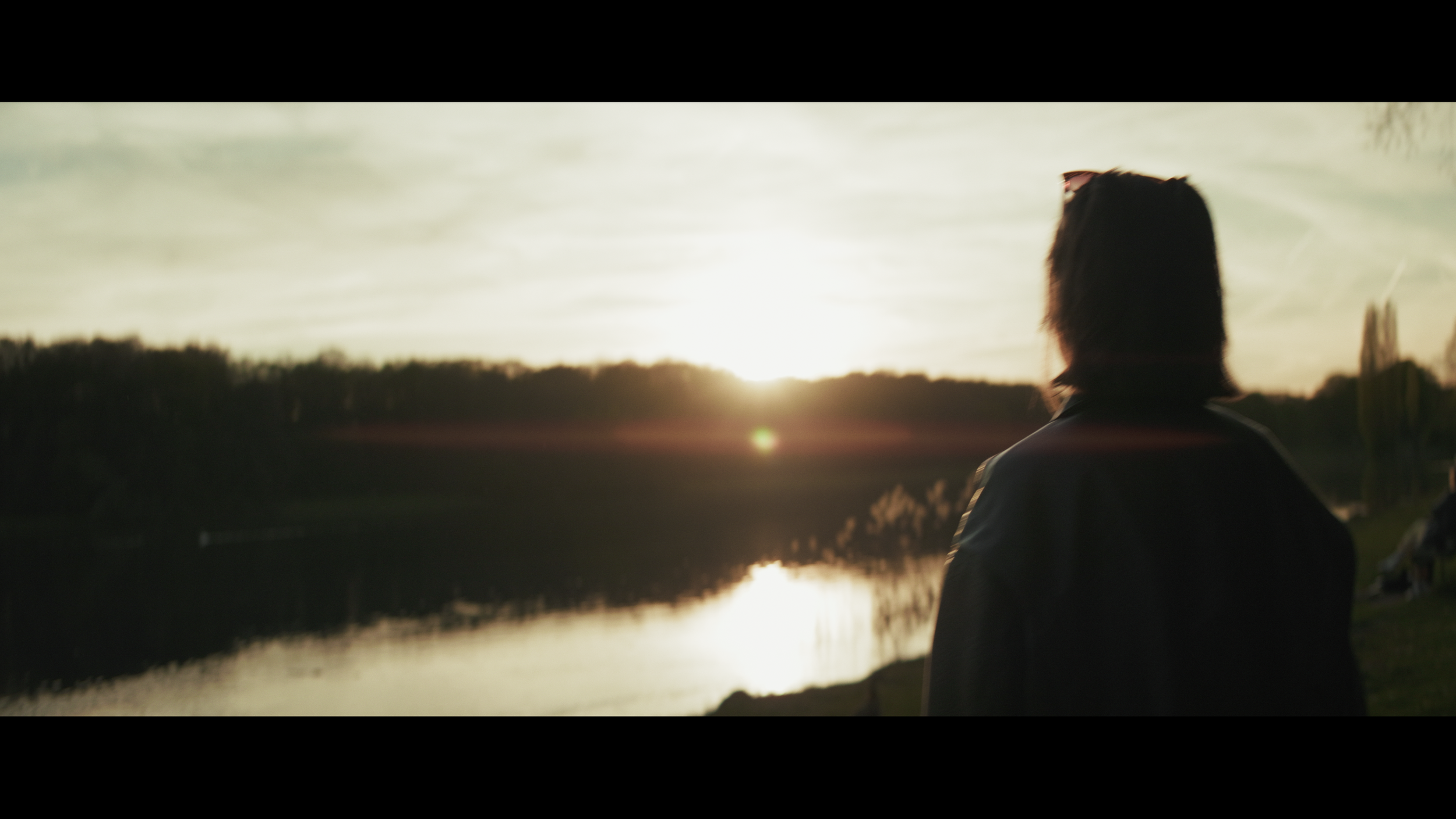 Frau am Decksteiner Weiher bei Sonnenuntergang gefilmt mit Blazar Mantis 50mm 1.33x Anamorphic Objektiv in Köln