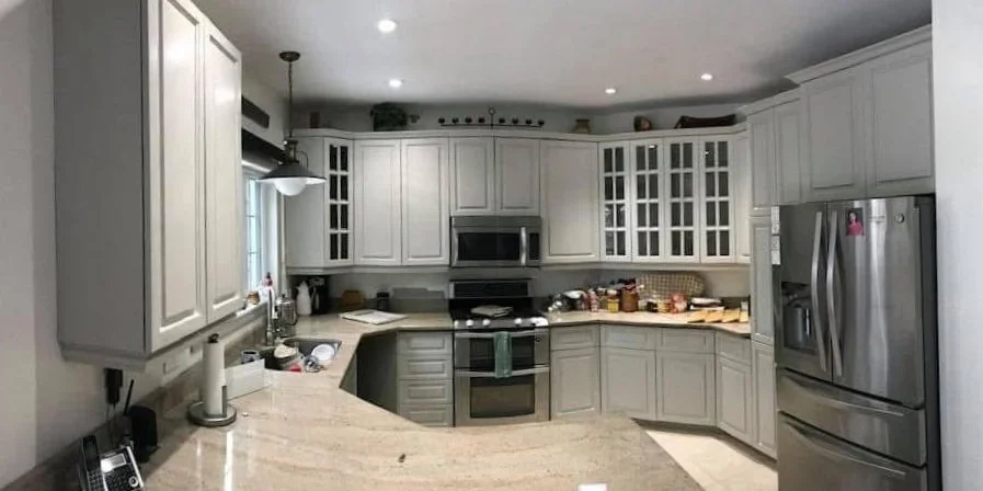 Kitchen with white cabinets, stainless steel refrigerator, microwave, and stove.