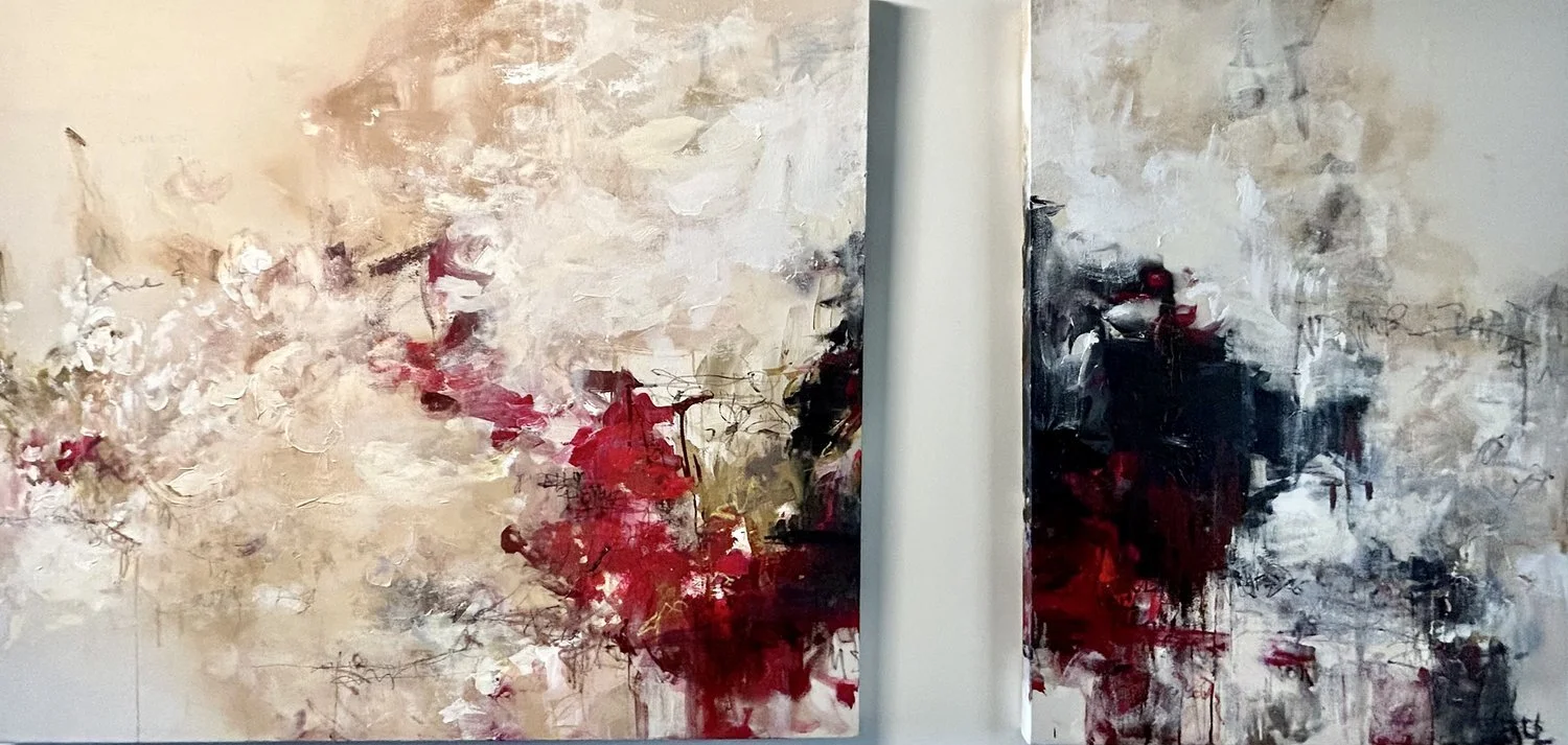 Two abstract paintings with bold brush strokes and splashes of red, black, white, and beige colors hanging on a wall separated by a small gap.
