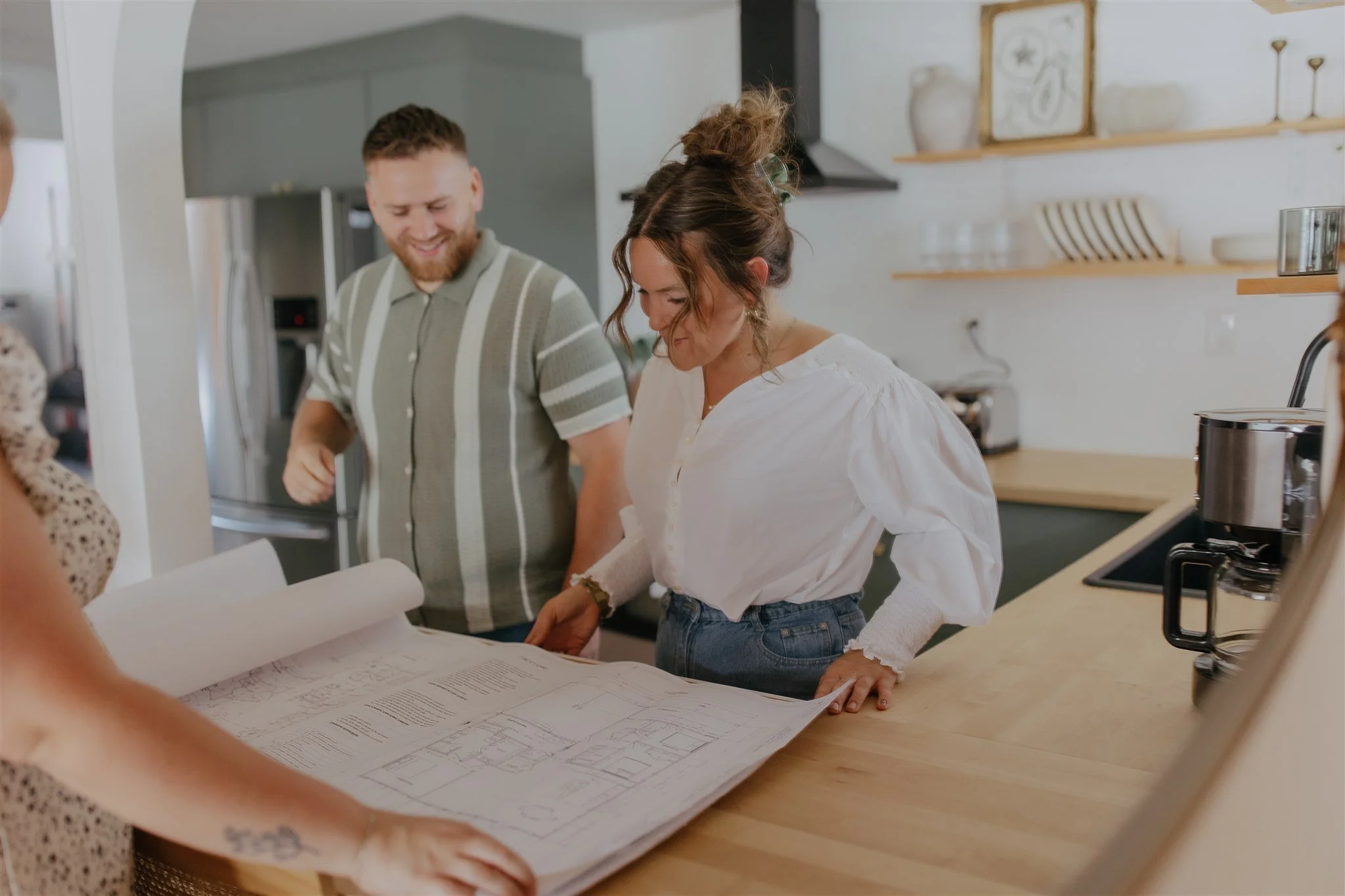 People in a Kitchen looking at Floor Plans for a Home Build