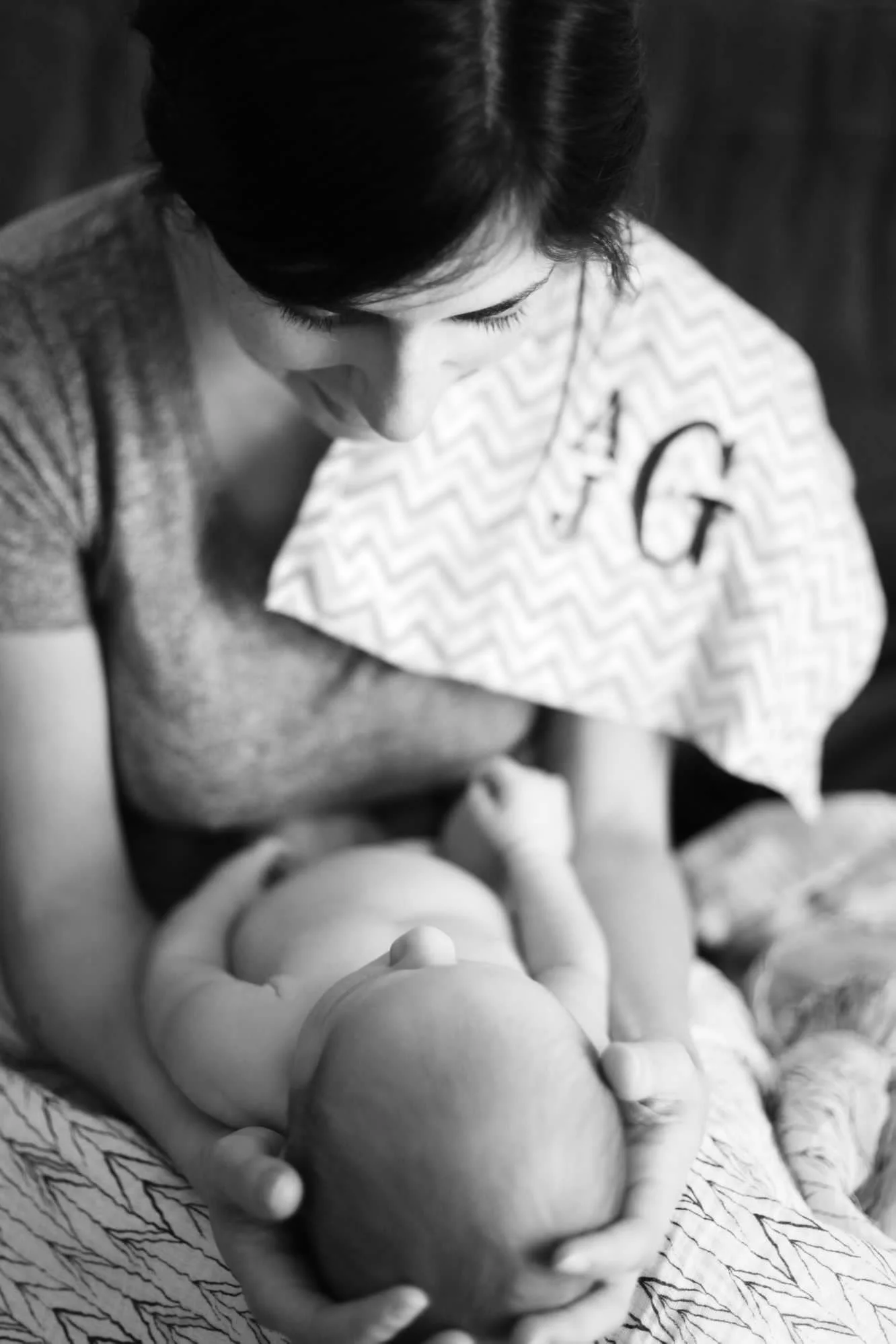 Mom holding a newborn baby ready to breastfeed.