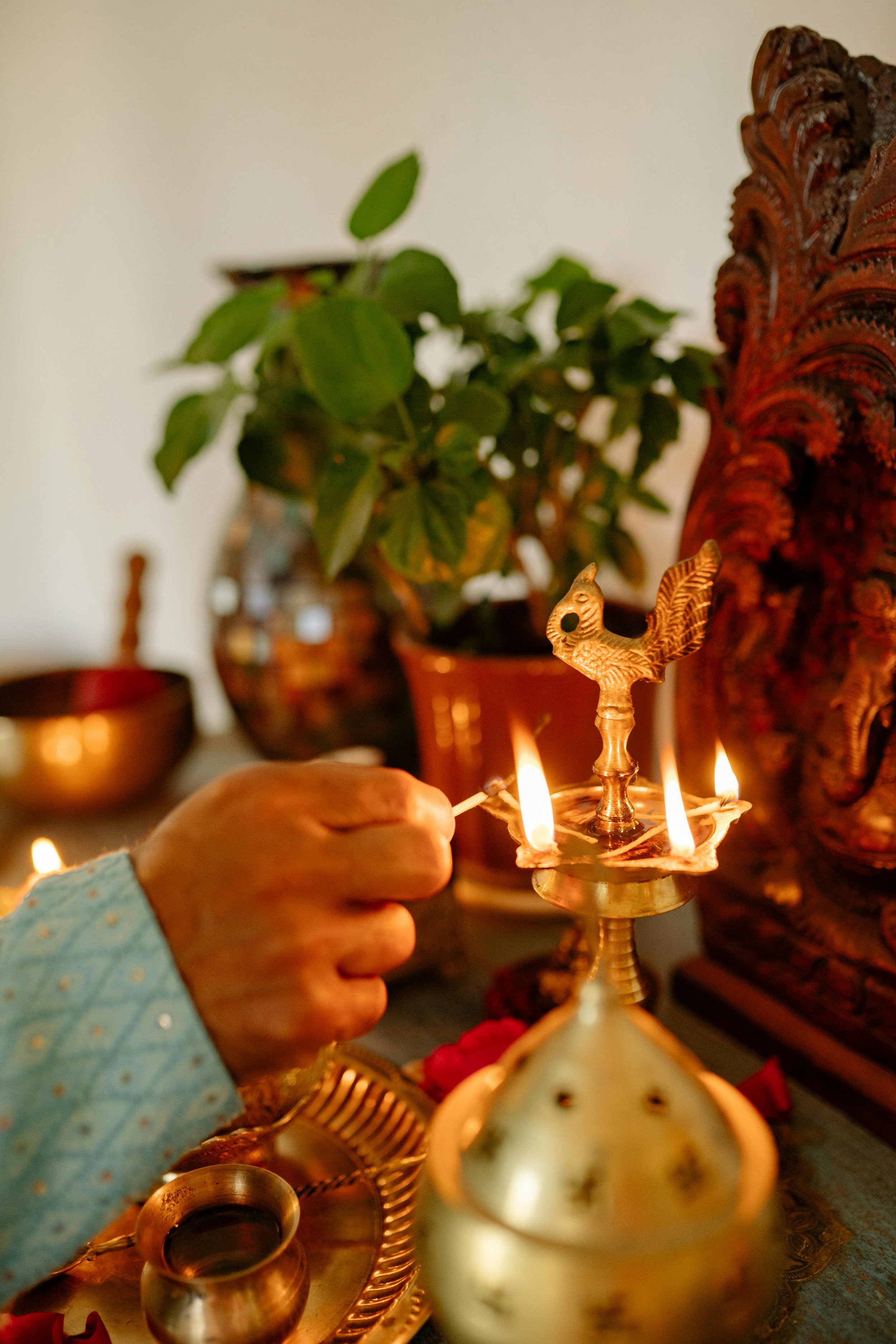 Traditional puja altar with lit oil lamps, flowers and henna – sacred blessing space at Spark Healing Toronto & Playa del Carmen
