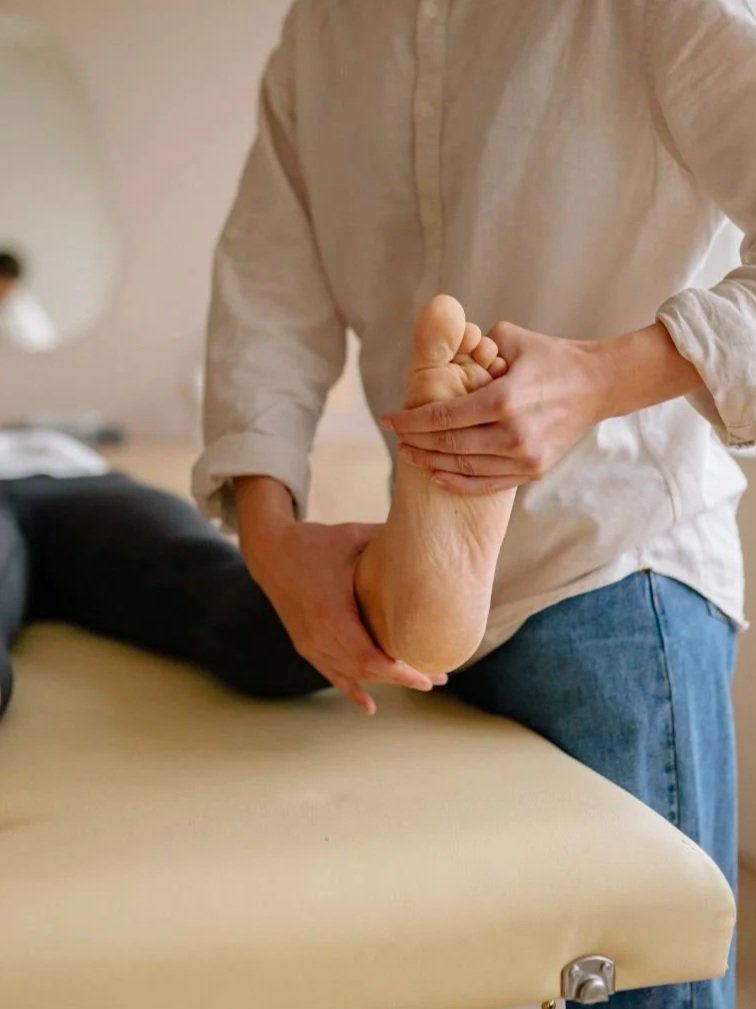 Woman physical stretching bottom of patient's foot and ankle.