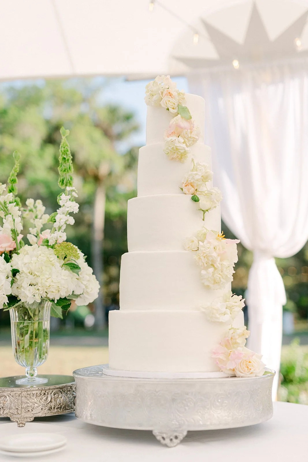 six-tier-white-wedding-cake-cascading-blush-roses-sailcloth-tent-tampa-wedding.jpg