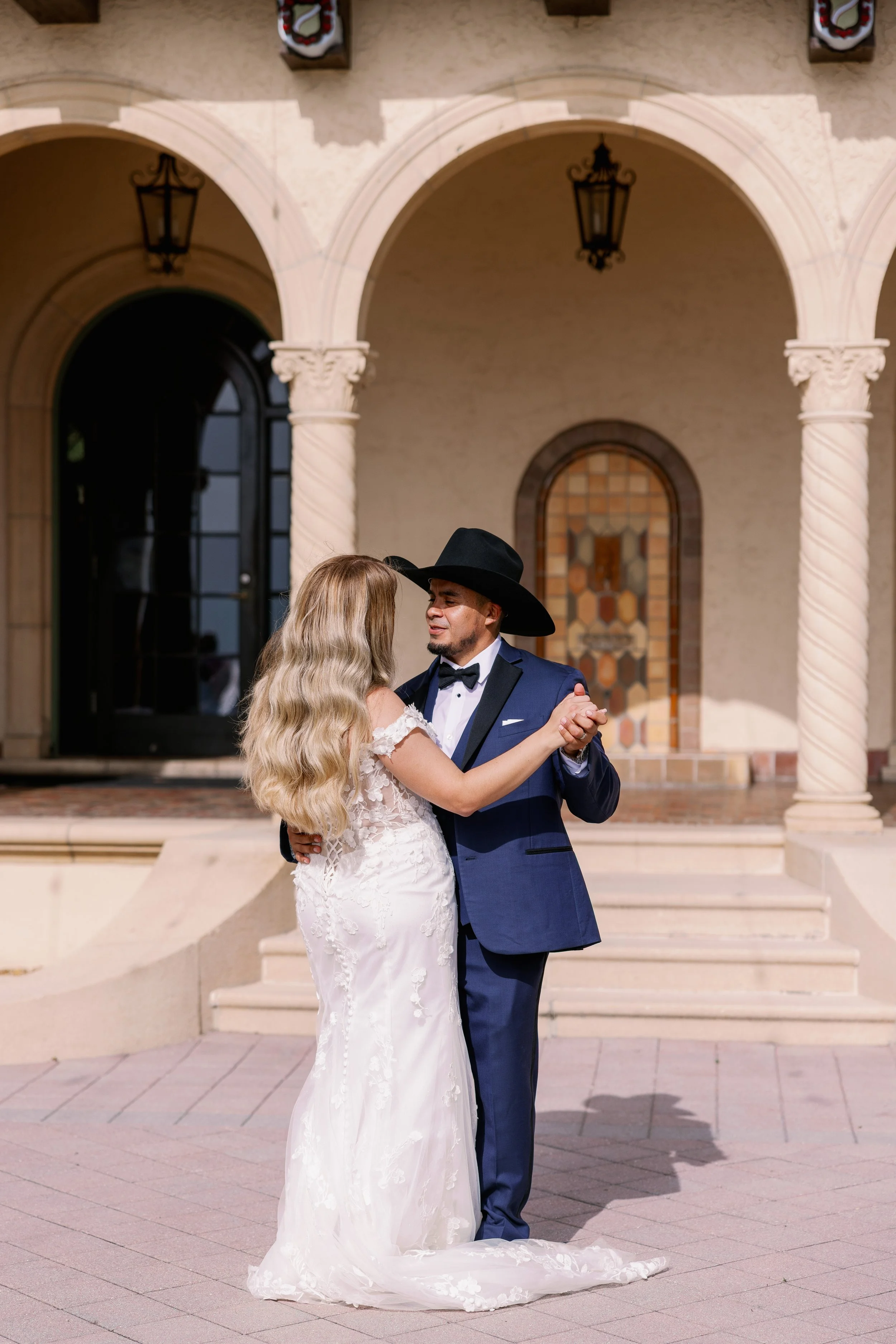bride-groom-kiss-balcony-cowboy-hat-silhouette-powel-crosley-estate-wedding-sarasota.jpg