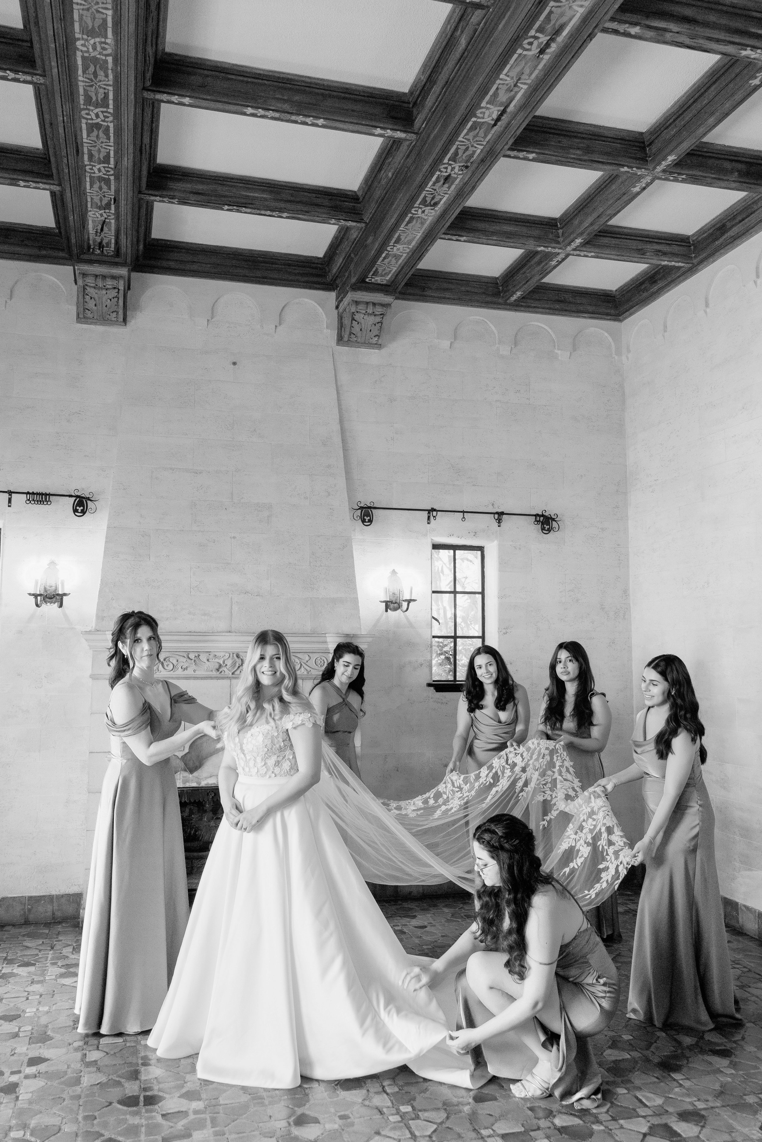 bridesmaids-helping-bride-dress-getting-ready-black-and-white-powel-crosley-estate-wedding-sarasota.jpg