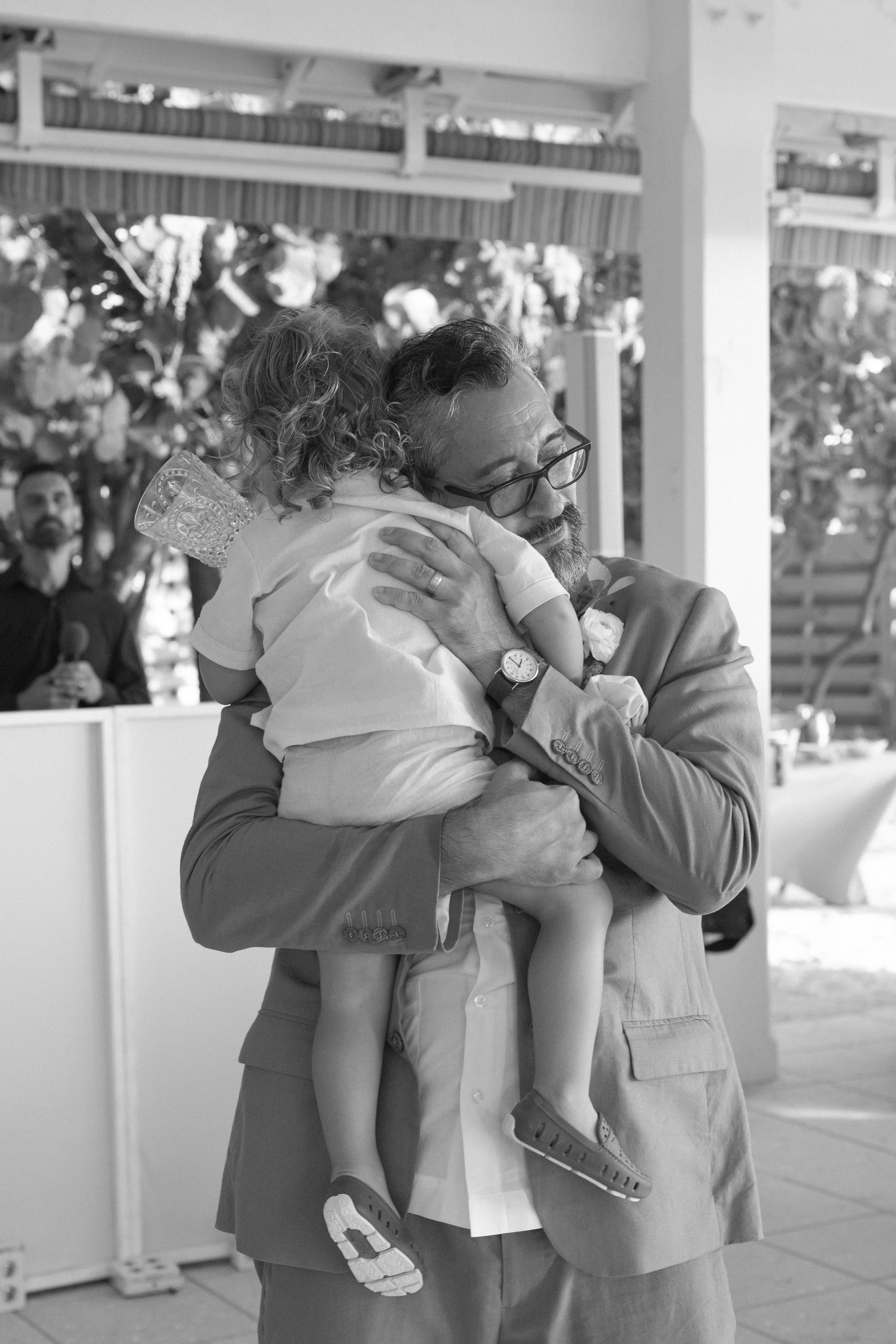 bride-embracing-child-candid-emotional-grand-pavilion-sandbar-wedding.jpg