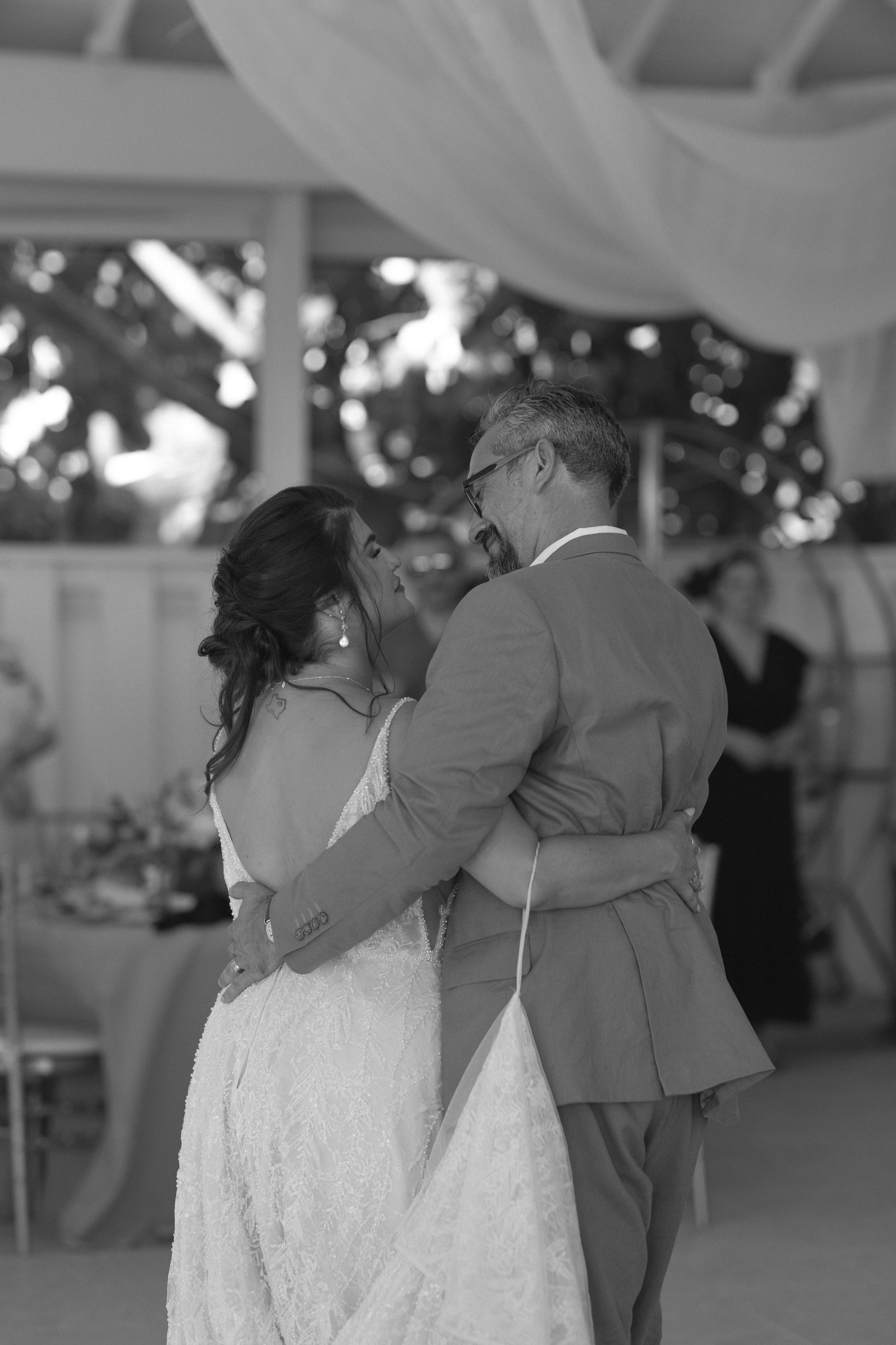 bride-groom-ceremony-embrace-black-and-white-grand-pavilion-sandbar-wedding.jpg
