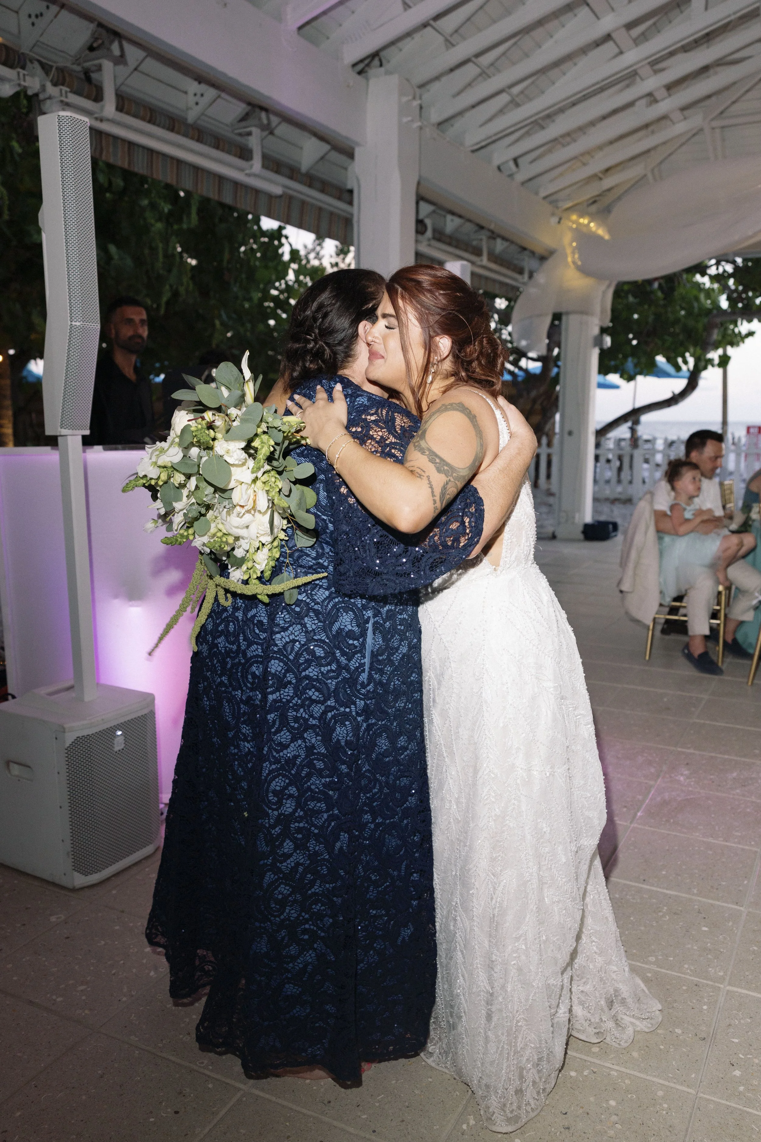 bride-groom-close-embrace-outdoor-patio-grand-pavilion-sandbar-wedding.jpg