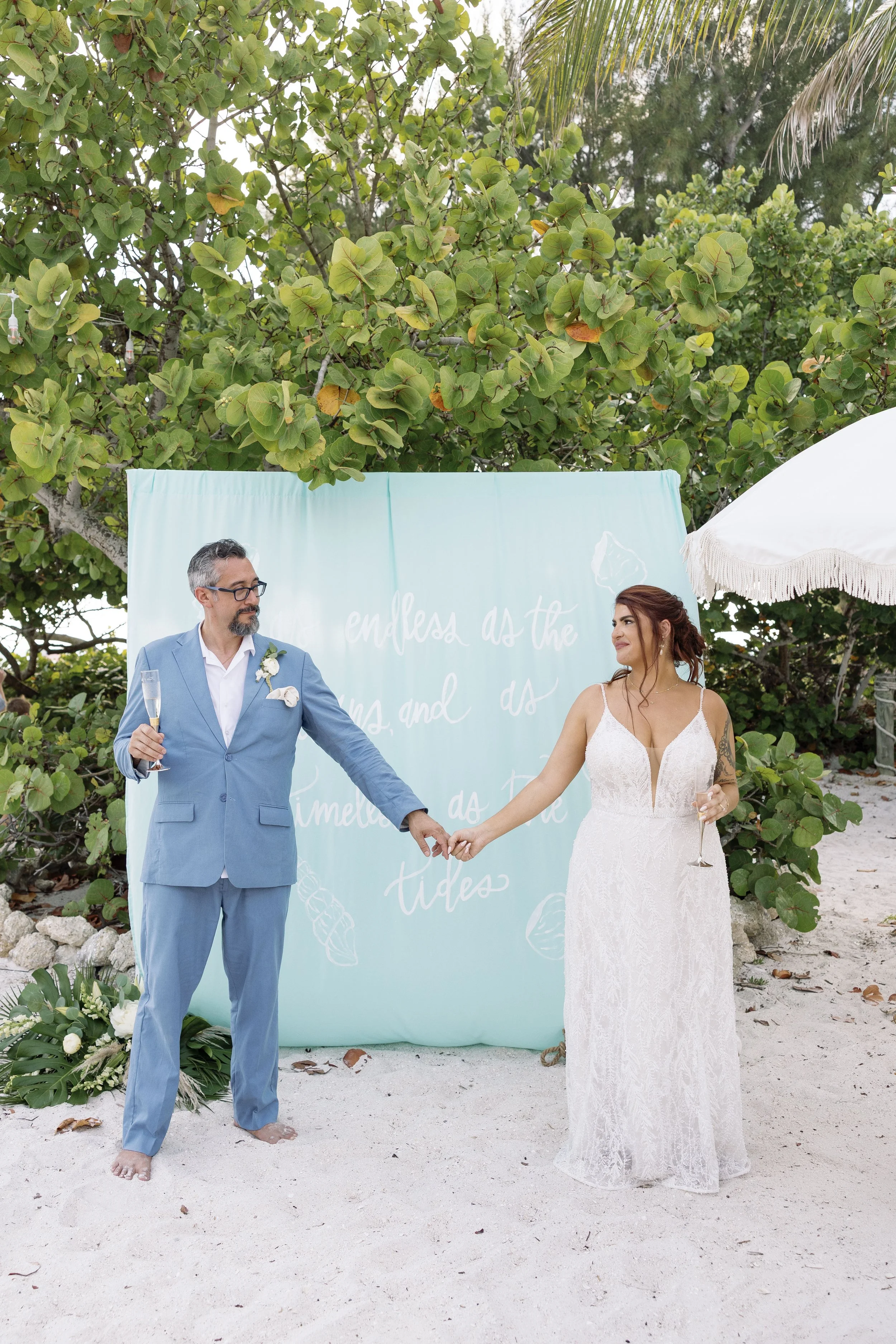 bride-groom-walking-hand-in-hand-beach-grand-pavilion-sandbar-wedding.jpg