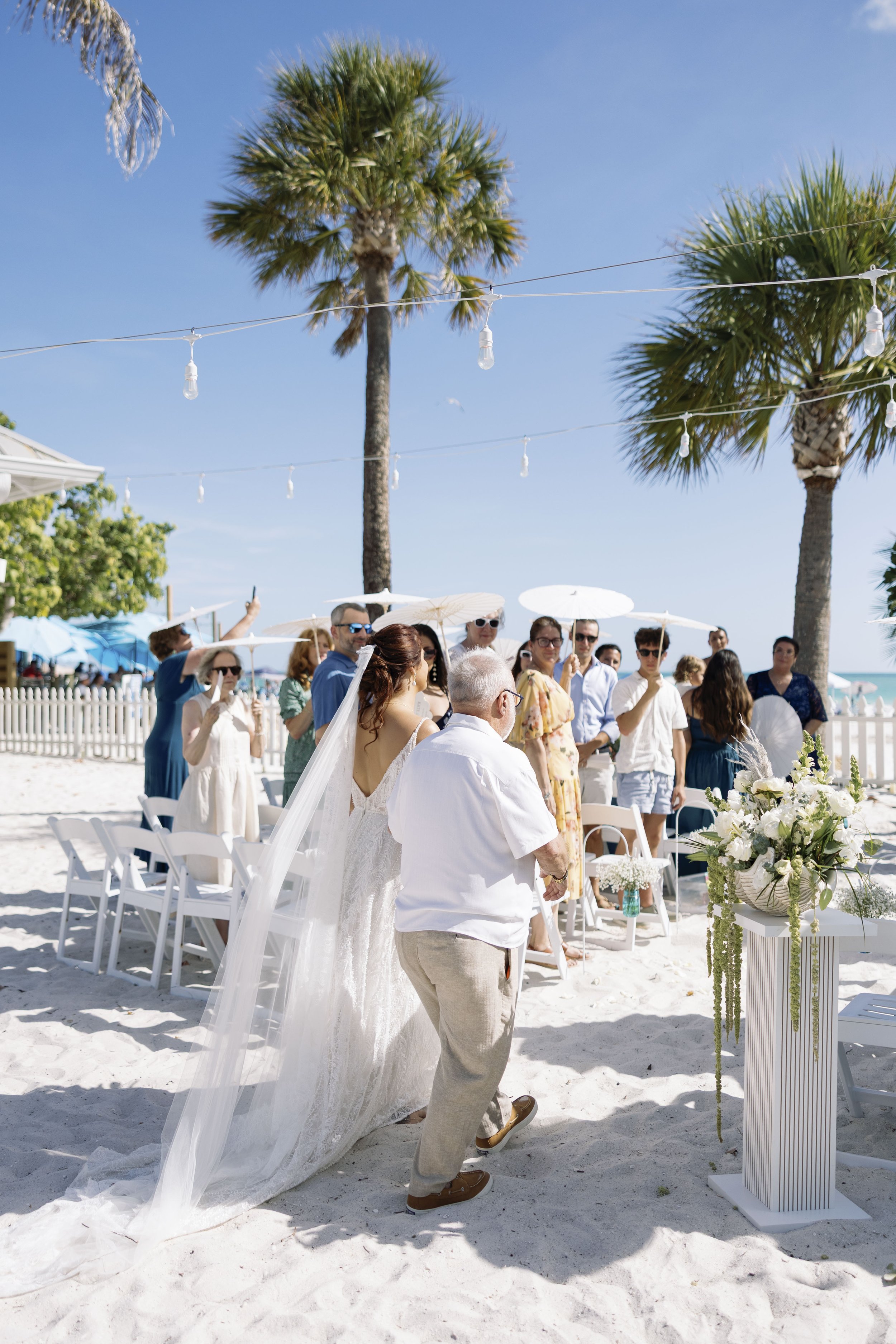 bride-walking-aisle-guests-seated-beach-ceremony-grand-pavilion-sandbar-wedding.jpg