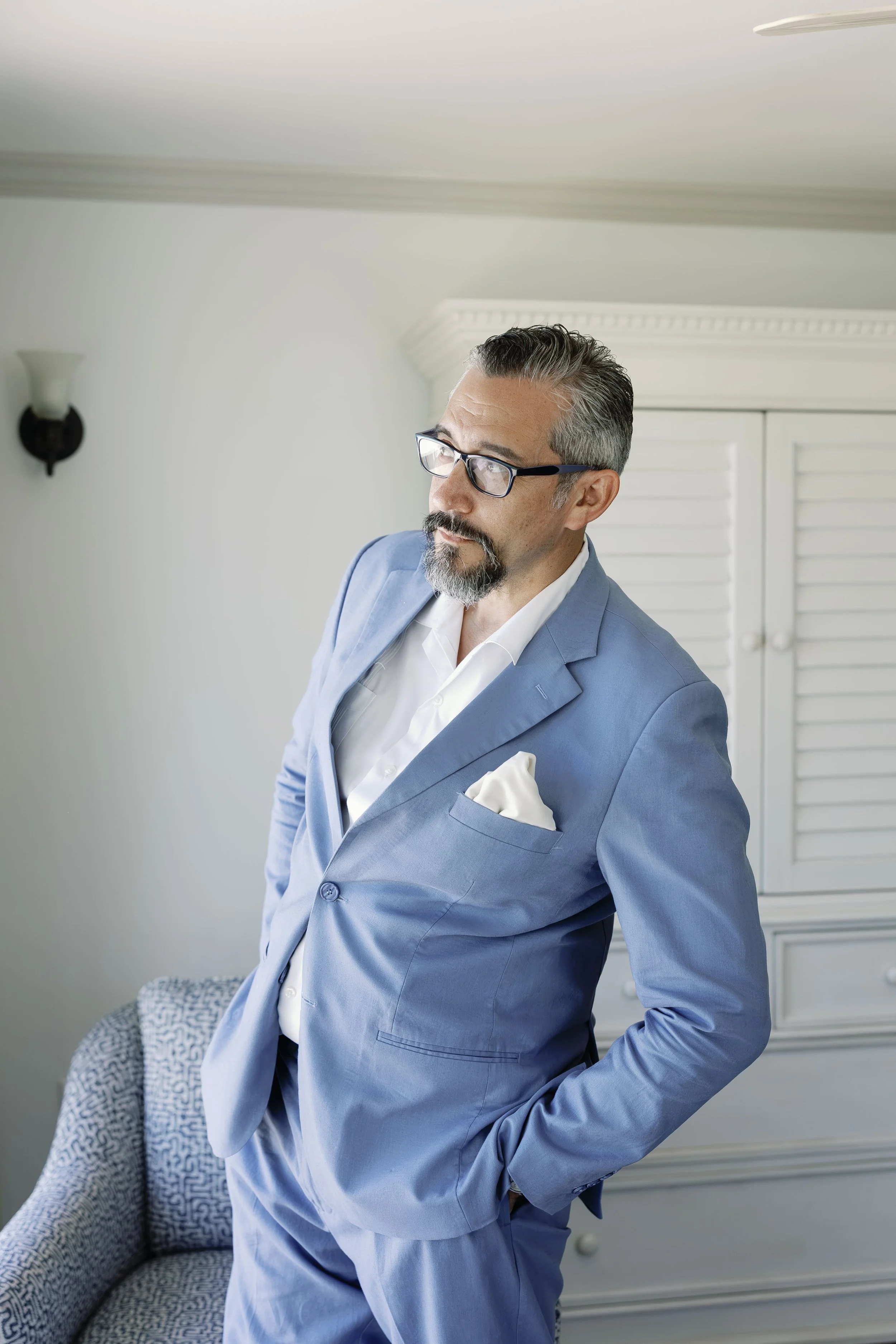 groom-solo-portrait-light-blue-suit-seated-grand-pavilion-sandbar-wedding.jpg