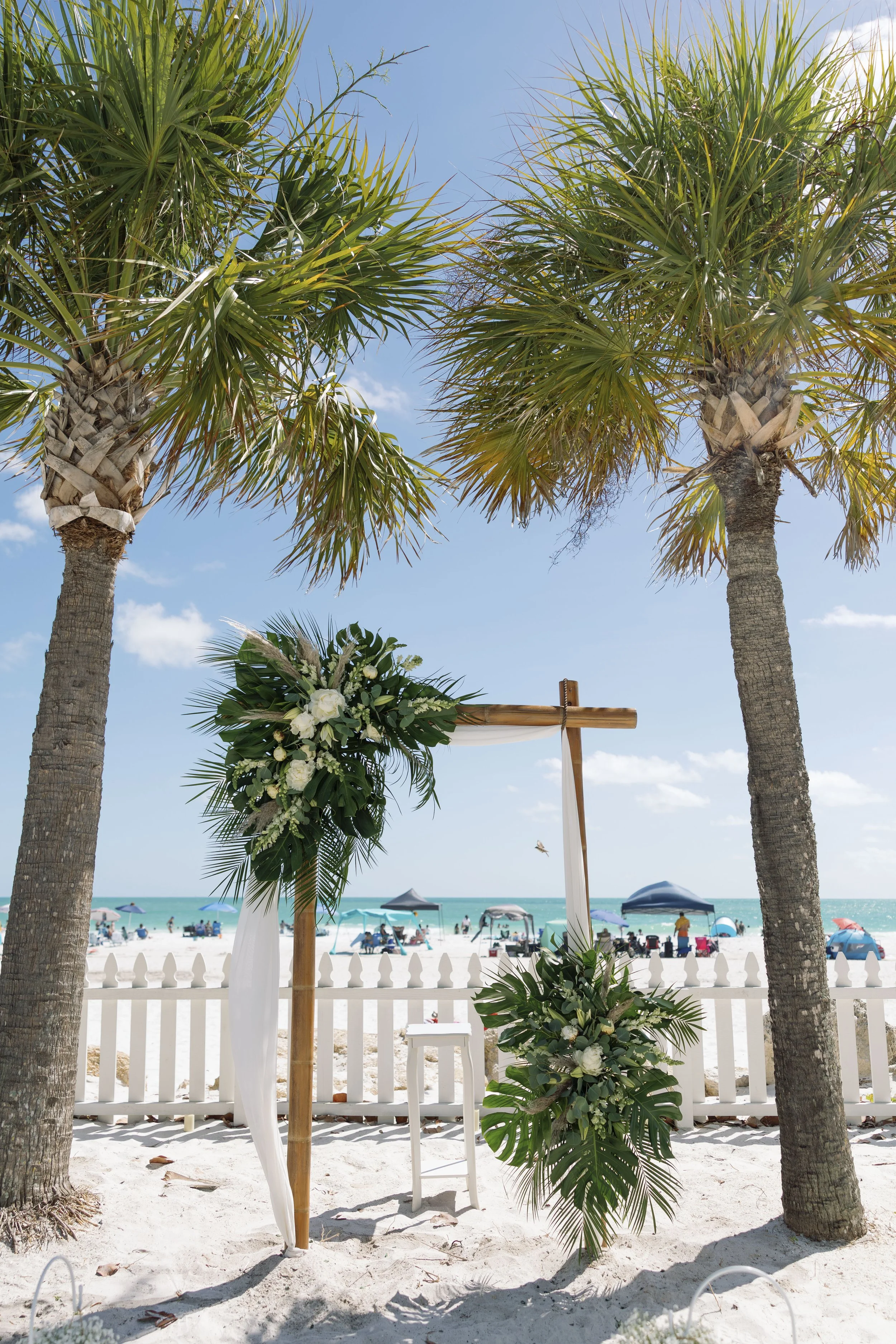 palm-trees-ceremony-arch-white-florals-beach-grand-pavilion-sandbar-anna-maria-island-wedding.jpg