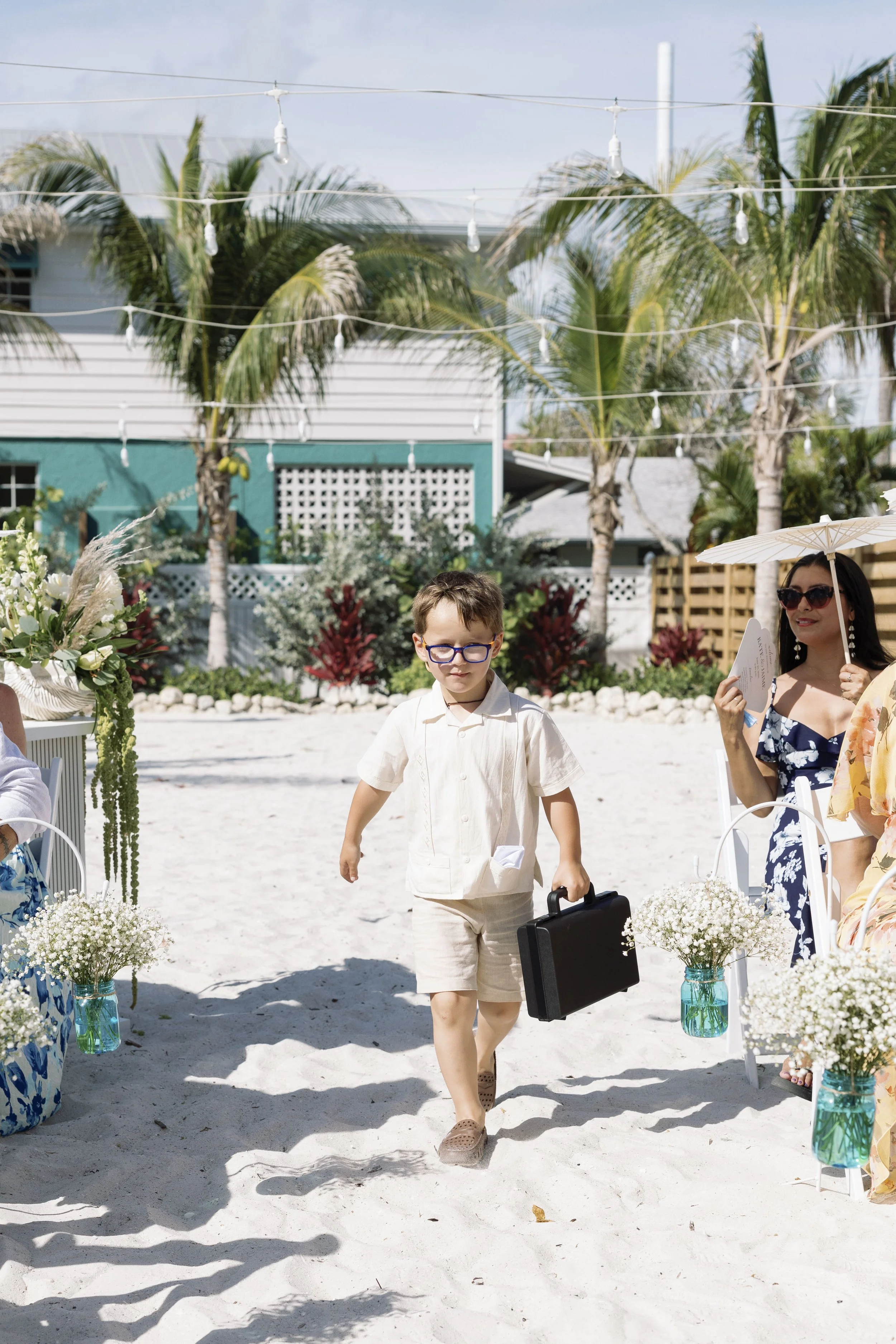 ring-bearer-walking-aisle-beach-ceremony-grand-pavilion-sandbar-wedding.jpg