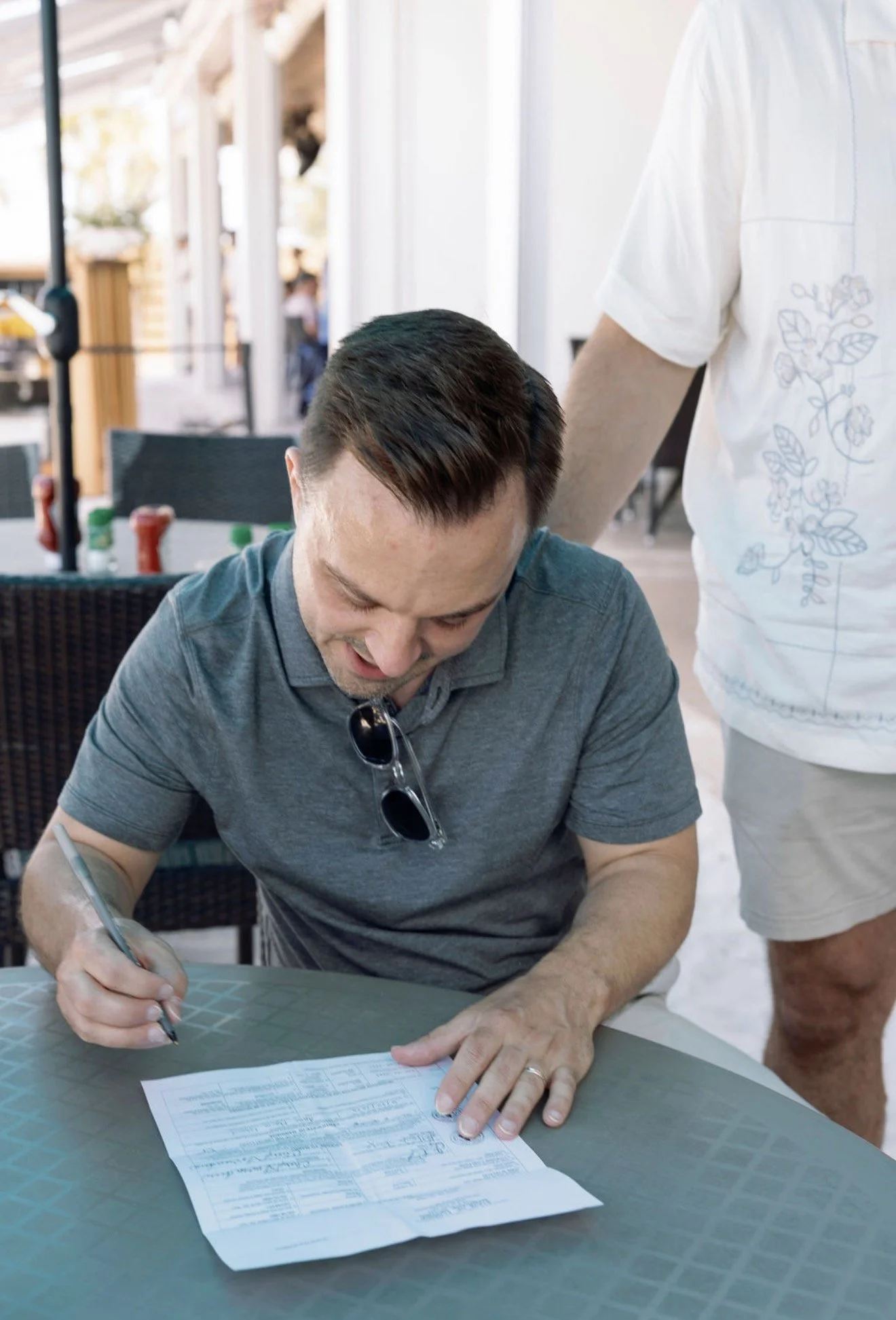 groom-signing-guest-book-black-and-white-beach-house-brunch-anna-maria-island-wedding.png